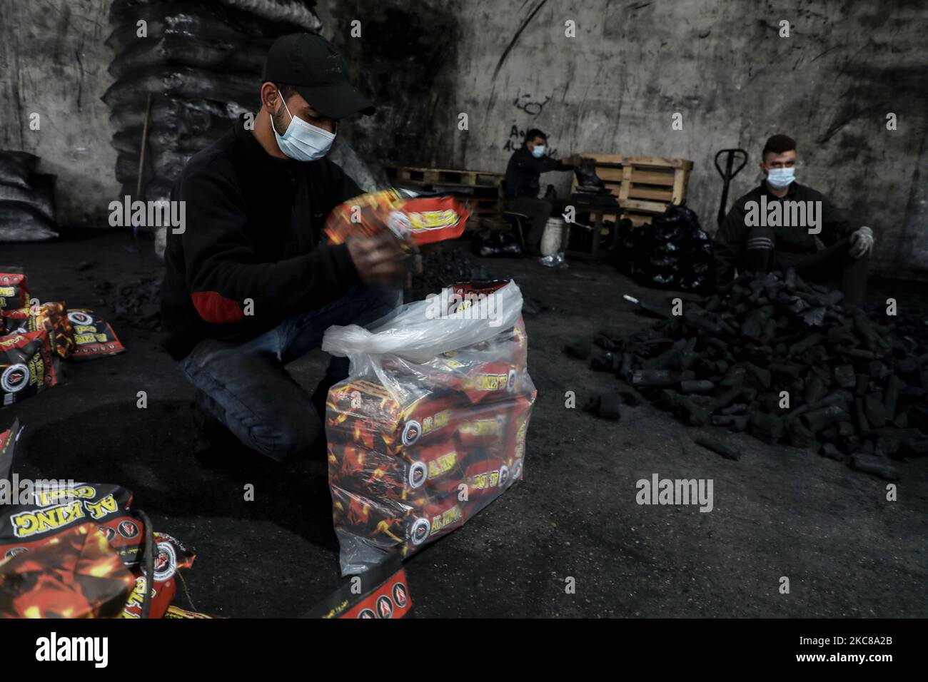 Un travailleur palestinien recueille le charbon de bois qui sera emballé dans des sacs pour le vendre à Jabaliya, dans le nord de la bande de Gaza, le 28 janvier 2021. (Photo de Majdi Fathi/NurPhoto) Banque D'Images