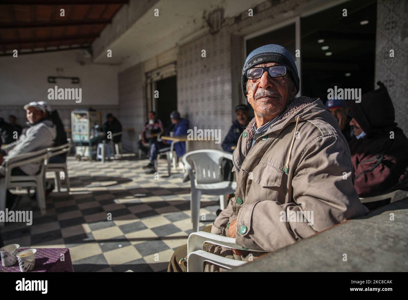 Un homme âgé pose pour des photos dans un café de Nogra qui est un quartier difficile des quartiers difficiles de la ville populaire d'Ettadhamen, une des villes les plus peuplées de Tunis, Pris dans les rues lors d'une marche de protestation anti-gouvernementale en direction du bâtiment du Parlement de la ville de Bardo à Tunis, pour protester contre la brutalité de la police, Et d'exiger la libération de jeunes arrêtés par la police anti-émeute lors de manifestations violentes nocturnes qui ont éclaté à Ettadhamen et dans plusieurs villes de Tunisie, à la mi-janvier pendant plus d'une semaine. Ettadhamen ville dont le nom signifie « solidarit Banque D'Images
