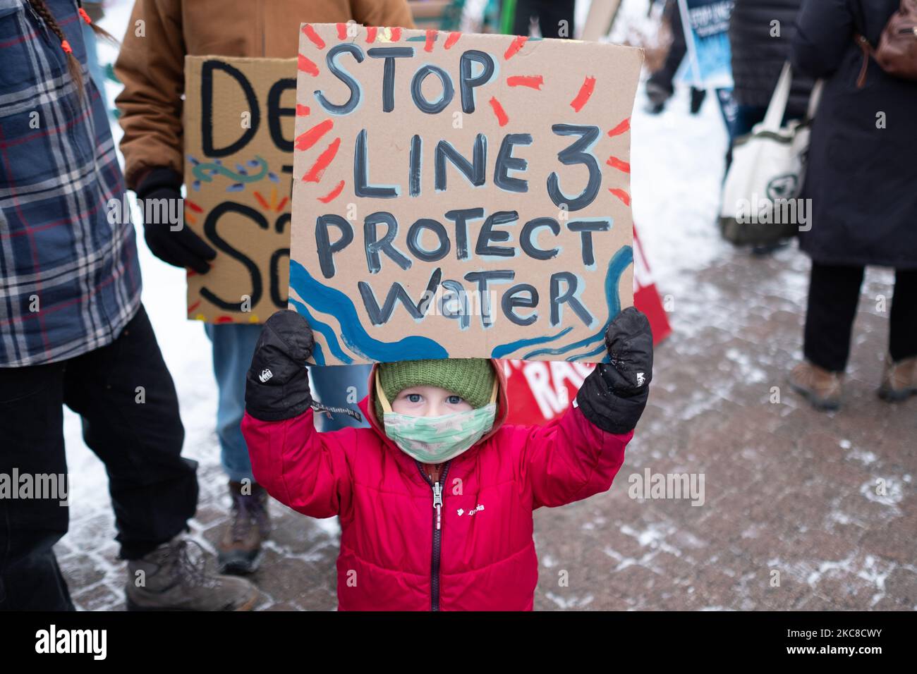 Un jeune manifestant tient un panneau indiquant « Protégez l'eau » lors d'une manifestation sur un pipeline de la ligne 3 dans le centre-ville de St. Paul, au Minnesota. 29 janvier 2021. Près de 600 activistes et protecteurs d'eau ont pris part vendredi soir à St. Paul, Minnesota, à une manifestation contre le pipeline de la ligne 3 d'Enbridge. L'événement a été organisé par plus d'une douzaine de groupes, dont Sunrise Movement MN, Honor the Earth, International Indigenous Youth Council, Environment MN, MN350, et d'autres. Les participants ont demandé au gouverneur Tim Walz ainsi qu'à la Société des ingénieurs de l'Armée de terre de révoquer le permis du pipeline sur la sécurité environnementale et humanitaire Banque D'Images