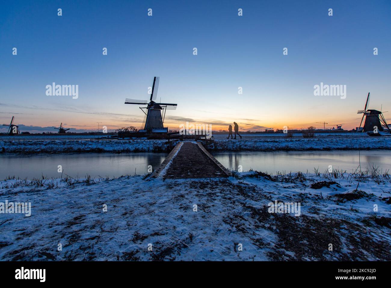 La magie de la sellerie autour de l'heure du coucher du soleil et de la tombée de la nuit avec ciel d'hiver clair sur les canaux gelés et les moulins à vent de Kinderdijk aux pays-Bas. Le pays est confronté à des conditions météorologiques arctiques, à des températures très basses, à des chutes de neige et à des vents violents en raison de la tempête Darcy qui a causé des problèmes dans les transports et dans la vie quotidienne. Beaucoup de canaux ont été gelés sous forme de glace car il y a une température inférieure à zéro du temps froid atteignant parfois -16C, alors que la terre est couverte de neige. Kinderdijk et les moulins à vent dans le polder d'Alblasserwaard, est une attraction célèbre, un monument hollandais et un site classé au patrimoine mondial de l'UNESCO, attint Banque D'Images