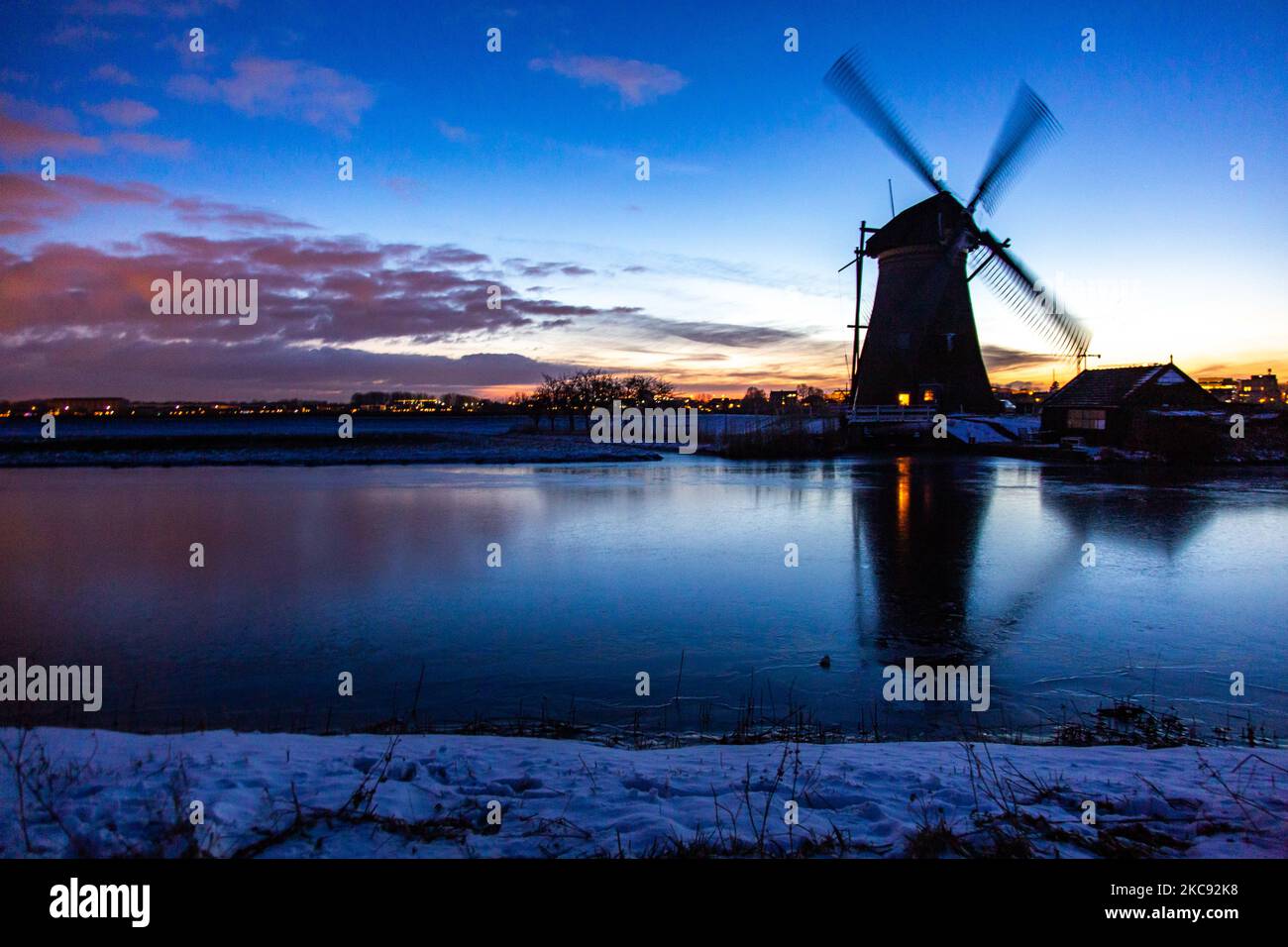 La magie de la sellerie autour de l'heure du coucher du soleil et de la tombée de la nuit avec ciel d'hiver clair sur les canaux gelés et les moulins à vent de Kinderdijk aux pays-Bas. Le pays est confronté à des conditions météorologiques arctiques, à des températures très basses, à des chutes de neige et à des vents violents en raison de la tempête Darcy qui a causé des problèmes dans les transports et dans la vie quotidienne. Beaucoup de canaux ont été gelés sous forme de glace car il y a une température inférieure à zéro du temps froid atteignant parfois -16C, alors que la terre est couverte de neige. Kinderdijk et les moulins à vent dans le polder d'Alblasserwaard, est une attraction célèbre, un monument hollandais et un site classé au patrimoine mondial de l'UNESCO, attint Banque D'Images