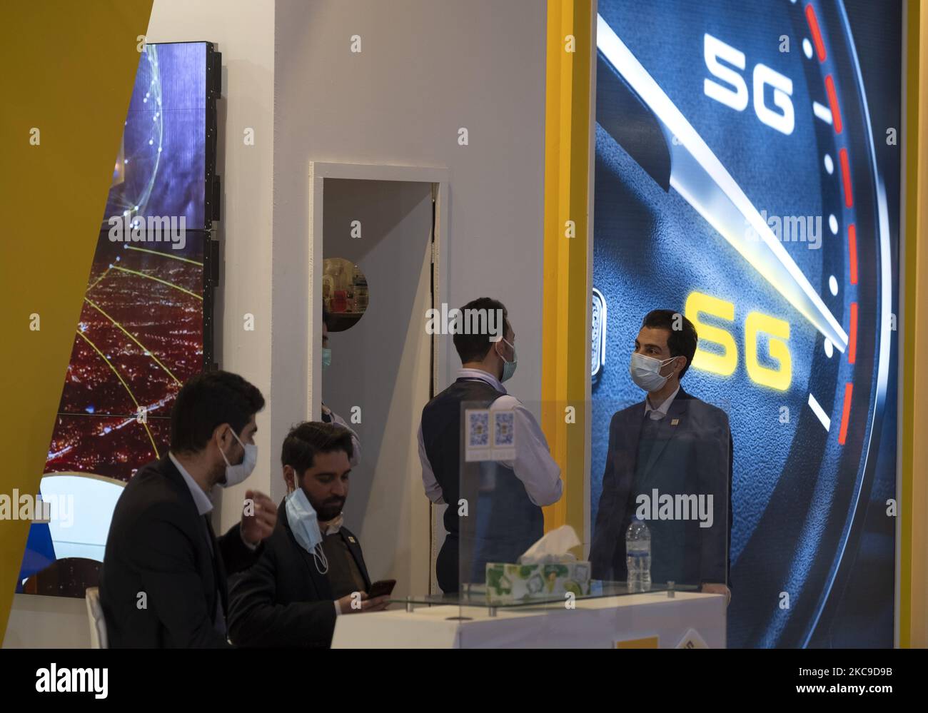 Les employés de la société iranienne de réseau mobile Irancell se parlent sous le logo 5G du sixième salon iranien Internet des objets (IoTex 2021) au Centre international d’exposition de Téhéran sur 16 février 2021. Le premier réseau 5G de l'Iran a été géré par la société Irancell, qui est une société iranienne de télécommunications qui exploite le plus grand réseau 2G-3G-4G-4,5G en Iran, également 5G réseaux mobiles et des services Internet fixes sans fil TD-LTE. (Photo de Morteza Nikoubazl/NurPhoto) Banque D'Images