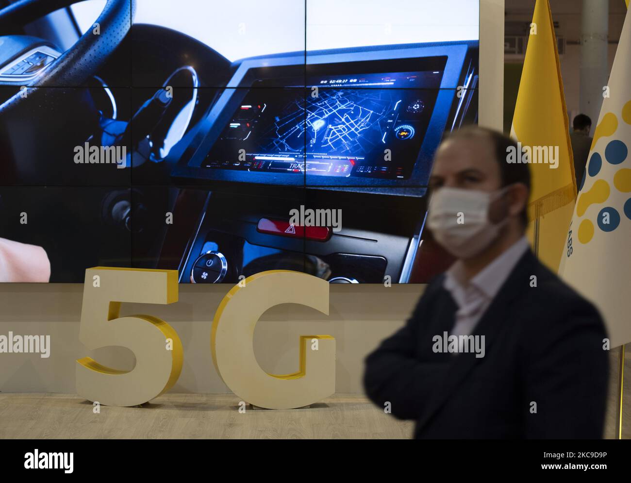 Un iranien portant un masque de protection regarde pendant qu’il passe devant le logo 5G de la société de réseau mobile d’Irancell sur le stand de la sixième exposition Iran sur l’Internet des objets (IoTex 2021) au Centre international d’exposition de Téhéran sur 16 février 2021. Le premier réseau 5G de l'Iran a été géré par la société Irancell, qui est une société iranienne de télécommunications qui exploite le plus grand réseau 2G-3G-4G-4,5G en Iran, également 5G réseaux mobiles et des services Internet fixes sans fil TD-LTE. (Photo de Morteza Nikoubazl/NurPhoto) Banque D'Images