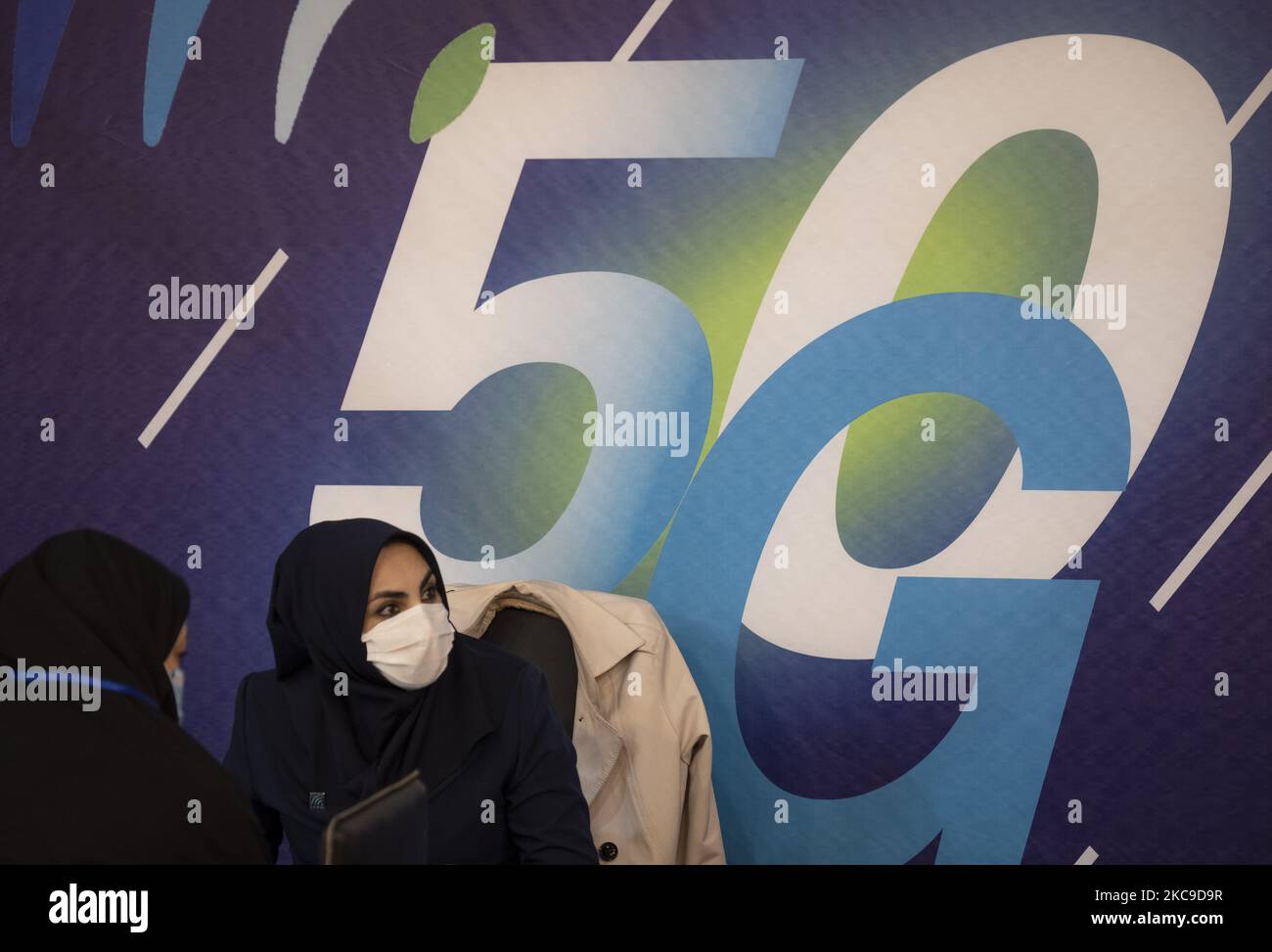 Une iranienne portant un masque facial protecteur se présente sous le logo 5G de la sixième exposition iranienne sur l’Internet des objets (IoTex 2021) au Centre international d’exposition de Téhéran sur 16 février 2021. Le premier réseau 5G de l'Iran a été géré par la société Irancell, qui est une société iranienne de télécommunications qui exploite le plus grand réseau 2G-3G-4G-4,5G en Iran, également 5G réseaux mobiles et des services Internet fixes sans fil TD-LTE. (Photo de Morteza Nikoubazl/NurPhoto) Banque D'Images