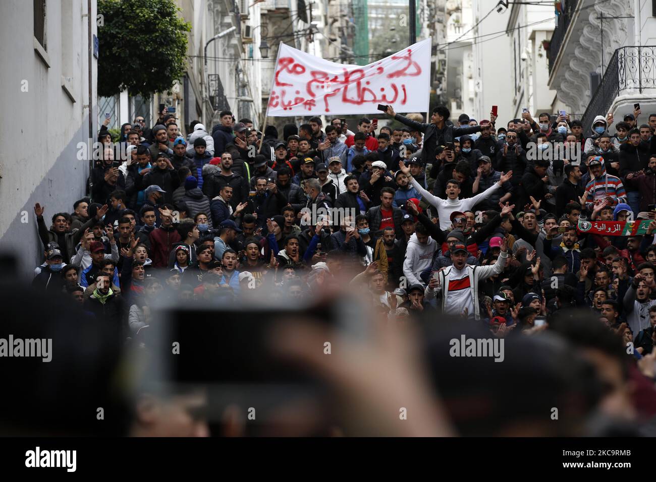 Les Algériens ont un drapeau national avec l'inscription arabe portant la mention alors qu'ils marchent pour marquer le deuxième anniversaire des manifestations populaires à Alger, Algérie sur 22 février 2021. L'Algérie célèbre le deuxième anniversaire du mouvement à l'occasion de la manifestation de masse de 22 février 2021, connue sous le nom de Hirak, qui a conduit à la démission du président de l'époque Abdelaziz Bouteflika. L'actuel président algérien Abdelmadjid Tebbounne a annoncé à 18 février la grâce et la libération d'une soixantaine de personnes condamnées ou en attente de procès pour participation au mouvement de protestation Hirak. Il a également dit qu'il l'était Banque D'Images