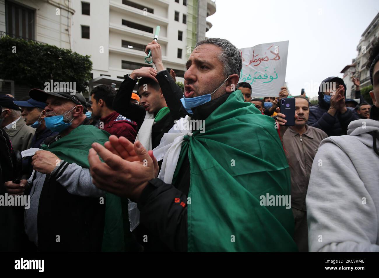 Les Algériens ont un drapeau national avec l'inscription arabe portant la mention alors qu'ils marchent pour marquer le deuxième anniversaire des manifestations populaires à Alger, Algérie sur 22 février 2021. L'Algérie célèbre le deuxième anniversaire du mouvement à l'occasion de la manifestation de masse de 22 février 2021, connue sous le nom de Hirak, qui a conduit à la démission du président de l'époque Abdelaziz Bouteflika. L'actuel président algérien Abdelmadjid Tebbounne a annoncé à 18 février la grâce et la libération d'une soixantaine de personnes condamnées ou en attente de procès pour participation au mouvement de protestation Hirak. Il a également dit qu'il l'était Banque D'Images