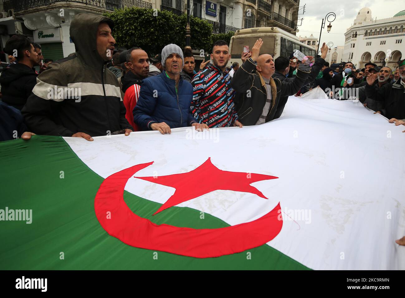 Les Algériens ont un drapeau national avec l'inscription arabe portant la mention alors qu'ils marchent pour marquer le deuxième anniversaire des manifestations populaires à Alger, Algérie sur 22 février 2021. L'Algérie célèbre le deuxième anniversaire du mouvement à l'occasion de la manifestation de masse de 22 février 2021, connue sous le nom de Hirak, qui a conduit à la démission du président de l'époque Abdelaziz Bouteflika. L'actuel président algérien Abdelmadjid Tebbounne a annoncé à 18 février la grâce et la libération d'une soixantaine de personnes condamnées ou en attente de procès pour participation au mouvement de protestation Hirak. Il a également dit qu'il l'était Banque D'Images