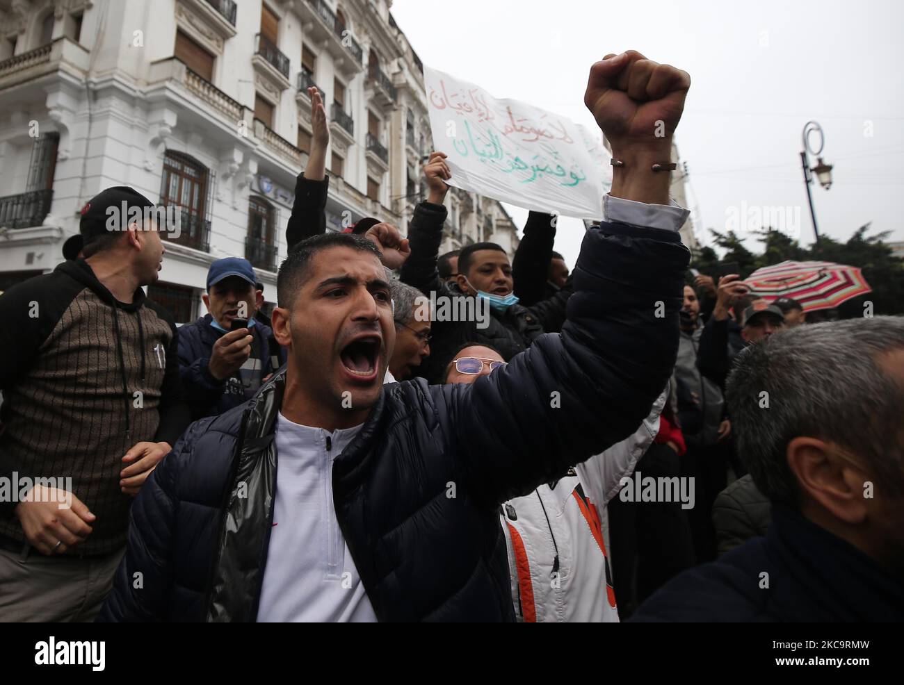 Les Algériens ont un drapeau national avec l'inscription arabe portant la mention alors qu'ils marchent pour marquer le deuxième anniversaire des manifestations populaires à Alger, Algérie sur 22 février 2021. L'Algérie célèbre le deuxième anniversaire du mouvement à l'occasion de la manifestation de masse de 22 février 2021, connue sous le nom de Hirak, qui a conduit à la démission du président de l'époque Abdelaziz Bouteflika. L'actuel président algérien Abdelmadjid Tebbounne a annoncé à 18 février la grâce et la libération d'une soixantaine de personnes condamnées ou en attente de procès pour participation au mouvement de protestation Hirak. Il a également dit qu'il l'était Banque D'Images