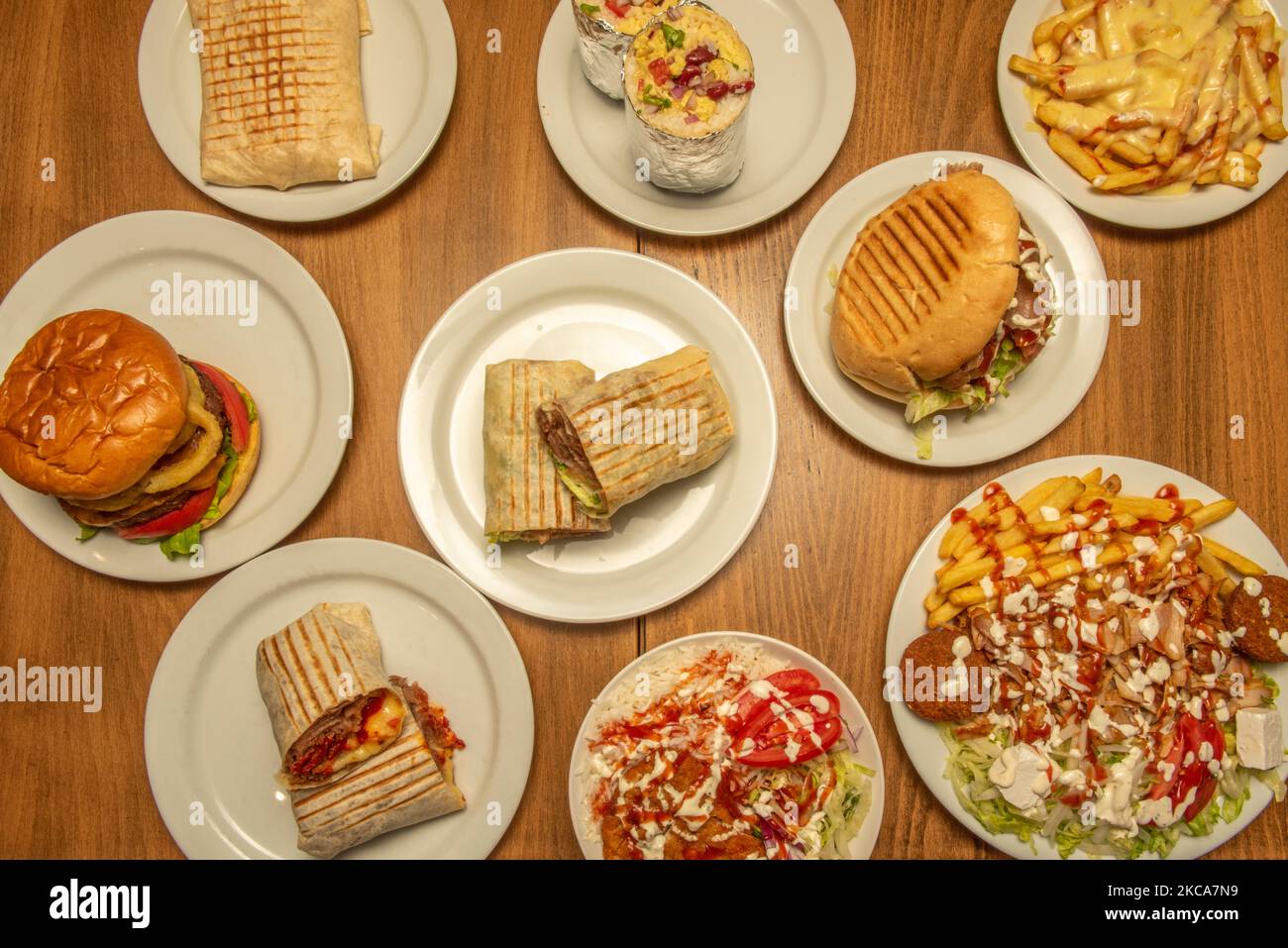 Ensemble de plats de restauration rapide avec hamburgers, burritos et plaques de blé dur et kebab avec falafel et sauces Banque D'Images