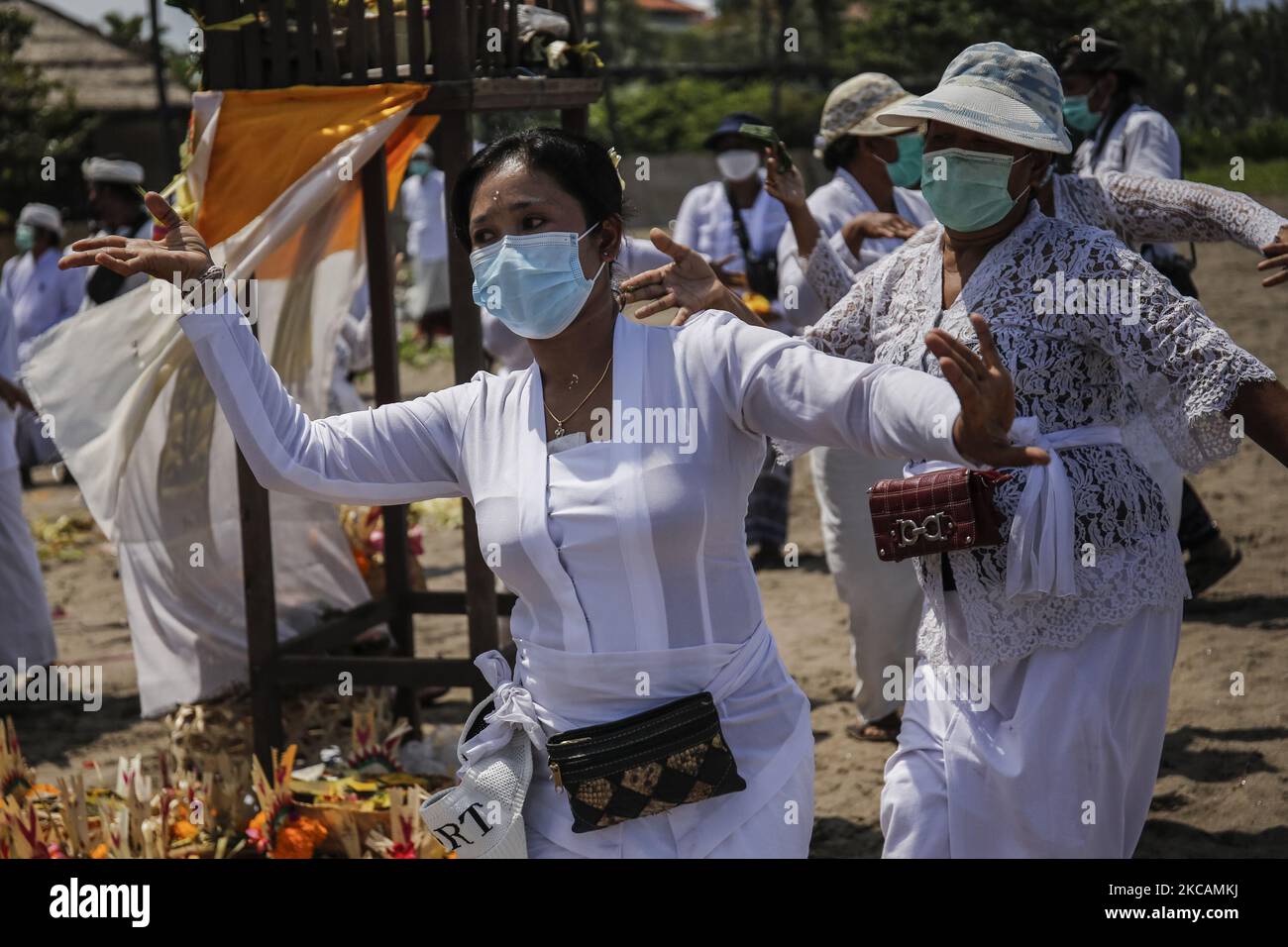 Les hindous balinais se préforment à la danse au cours de la cérémonie de purification appelée Melasti au milieu de la pandémie COVID-19 sur la plage de Denpasar, Bali, Indonésie sur 11 mars 2021. La cérémonie vise à nettoyer les âmes avant d'entrer dans le jour balinais du silence, marque la nouvelle année dans le calendrier hindou balinais qui tombe sur 14 mars. La cérémonie a généralement été suivie par des milliers de dévotés, mais pendant la pandémie COVID-19, peu de personnes ont été autorisées à se joindre au cortège. (Photo de Johannes Christo/NurPhoto) Banque D'Images