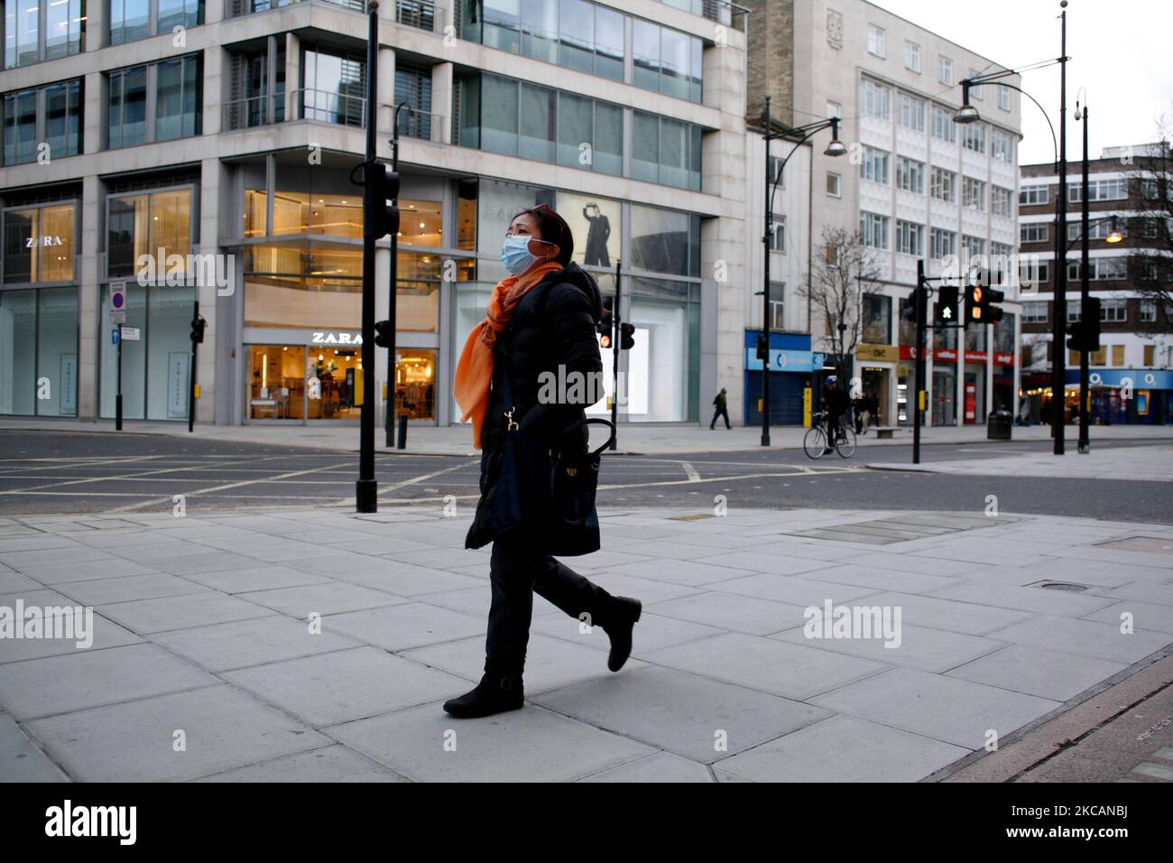 Une femme portant un masque de visage marche le long d'une Oxford Street presque déserte à Londres, en Angleterre, sur 11 mars 2021. Cette semaine a marqué la première étape de l'assouplissement du confinement des coronavirus dans toute l'Angleterre, avec la réouverture des écoles et quelques limites sur les contacts sociaux assouplies. Les magasins, bars, restaurants et autres commerces d'accueil et de loisirs non essentiels restent toutefois fermés et ne rouvriront pas avant le mois prochain selon les horaires en vigueur. (Photo de David Cliff/NurPhoto) Banque D'Images