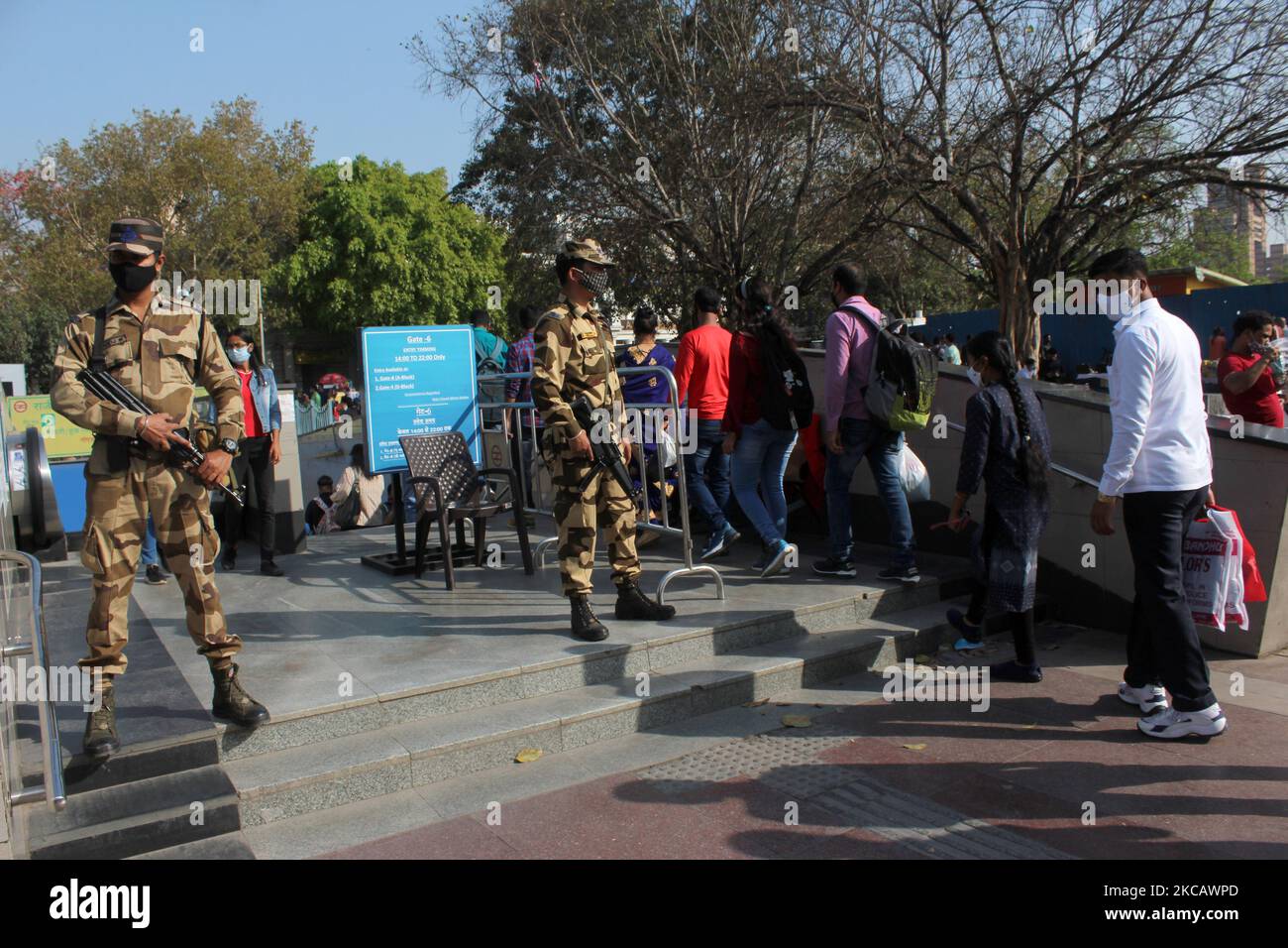 Le personnel de sécurité garde tandis que les navetteurs font la queue pour entrer à la station de métro Rajiv Chowk en raison de la pandémie de virus corona (COVID-19), à New Delhi, en Inde, sur 14 mars 2021. (Photo de Mayank Makhija/NurPhoto) Banque D'Images