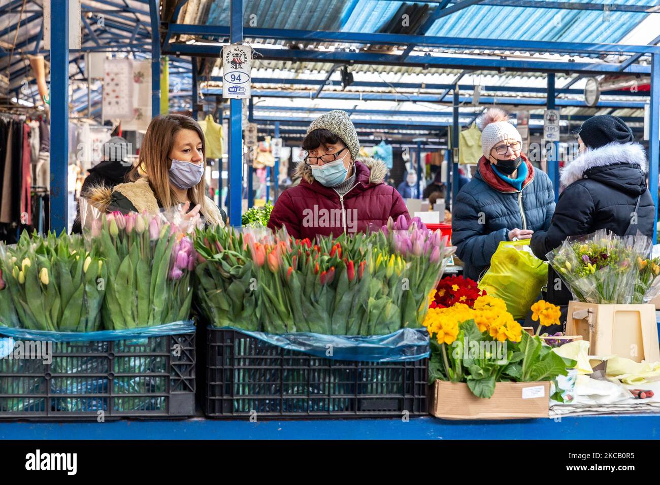 Les femmes vendent des fleurs de printemps à la place du marché en plein air Old Kleparz dans la vieille ville de Cracovie alors que les gens commencent à se préparer pour les vacances de Pâques parmi le nombre croissant de cas Covid-19 en Pologne sur 16 mars 2021. Pâques est une fête familiale et religieuse importante en Pologne. Alors que la Pologne se tient face à la peur de la troisième vague de coronavirus, les familles pourraient ne plus pouvoir passer les vacances ensemble. (Photo par Dominika Zarzycka/NurPhoto) Banque D'Images