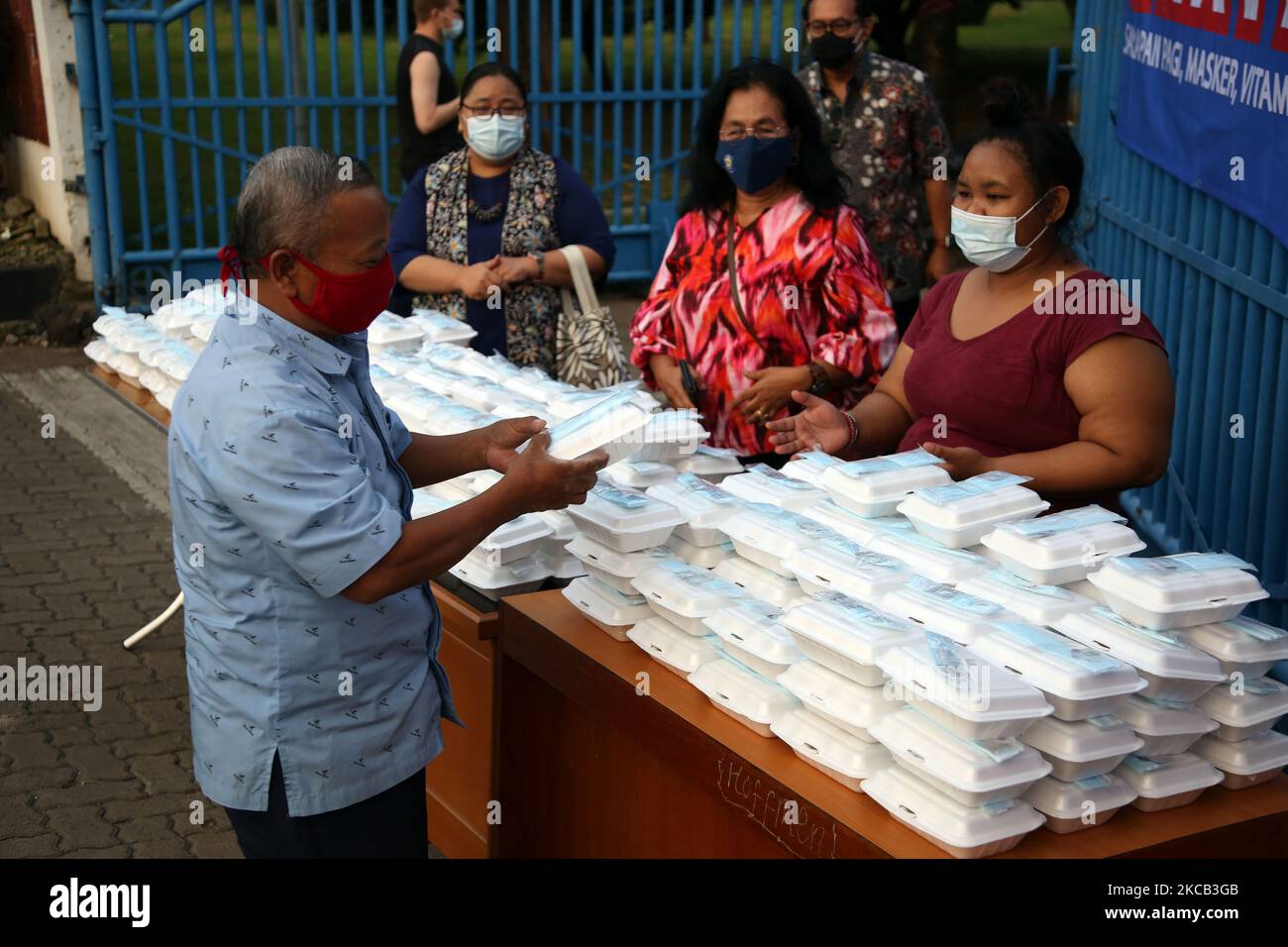 Les résidents prennent le petit déjeuner, les masques et les vitamines en paquets sur la page d'accueil de l'Université chrétienne d'Indonésie (UKI) à Cawang, Jakarta, 18 mars 2021. L'action sociale est réalisée gratuitement pour les résidents touchés par la pandémie Covid-19 commence à 06 à 09 heures avec 500 paquets de nourriture, de masques et de vitamines pendant 3 mois. (Photo de Dasril Roszandi/NurPhoto) Banque D'Images