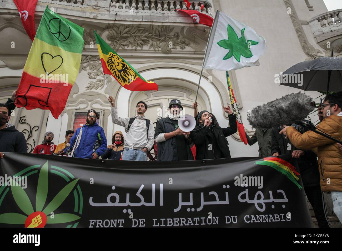 Les manifestants branle des drapeaux alors qu'ils tiennent une bannière avec un dessin de feuille de cannabis, Cela se lit en français et en arabe, le Front de libération du Kif, lors d'une manifestation organisée sur l'avenue Habib Bourguiba à Tunis, en Tunisie, sur 20 mars 2021, où les manifestants se sont rassemblés pour appeler à la décriminalisation et à la légalisation de l'usage du cannabis et à la libéralisation de sa commercialisation. Les jeunes manifestants ont également demandé la suspension de l'application de la loi 52 sur les stupéfiants, considérée comme répressive, et ont demandé pardon à tous ceux qui sont détenus pour usage de drogues. (Photo de Chehly Ben Ibrahim/Nur Banque D'Images