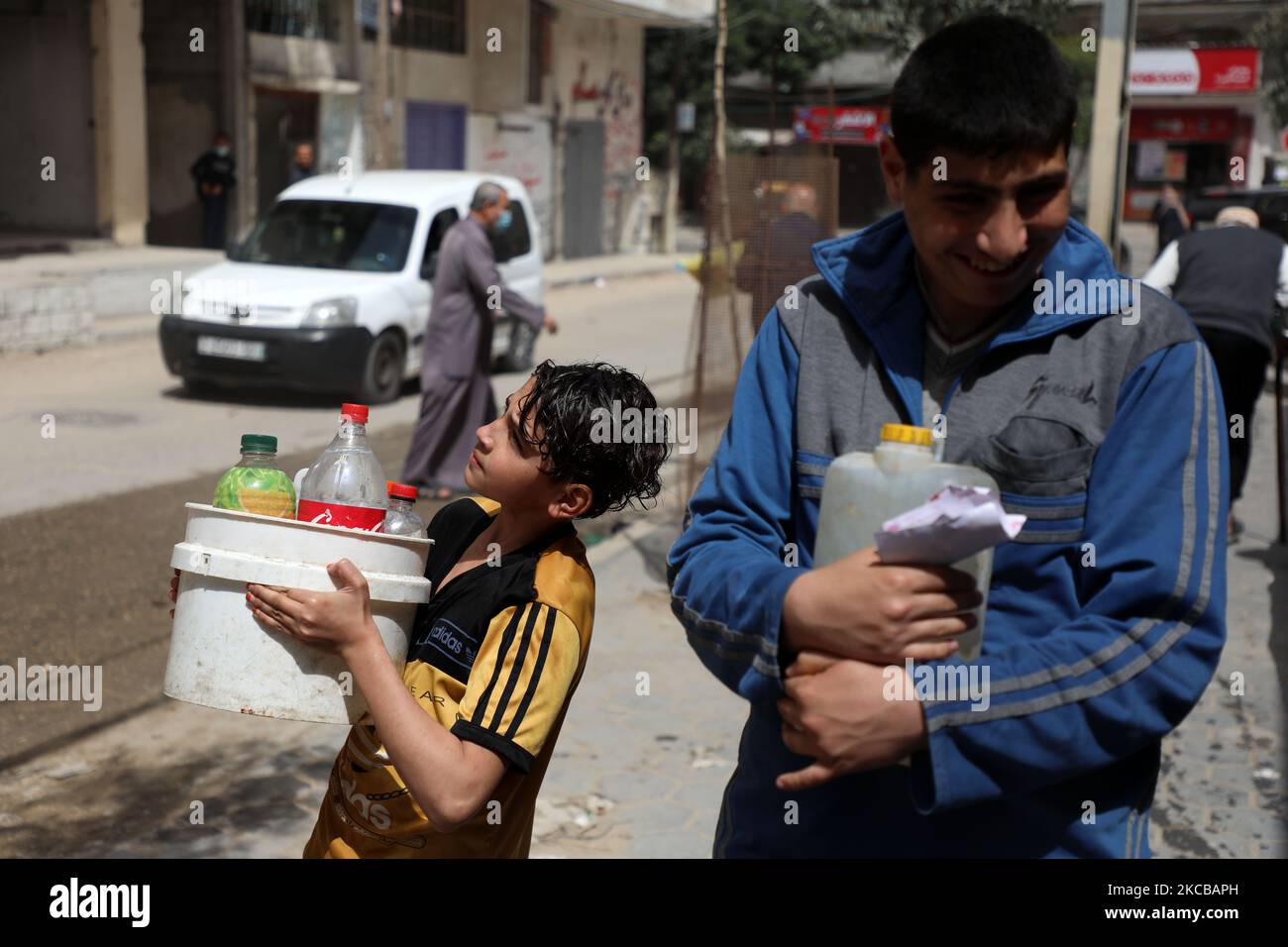 Les garçons palestiniens remplissent les bouteilles et les conteneurs d'eau d'un robinet public lors de la Journée mondiale de l'eau, journée de célébration des Nations Unies, dans la ville de Gaza, à 22 mars 2021. (Photo de Majdi Fathi/NurPhoto) Banque D'Images