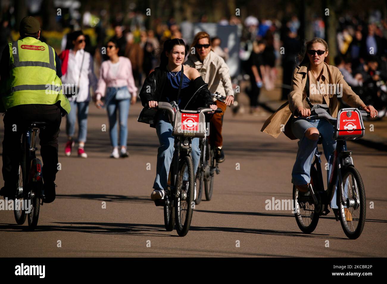 Une paire de femmes se promener « Boris Bikes » sous le soleil de printemps chaud au bord du lac de Serpentine à Hyde Park, à Londres, en Angleterre, sur 29 mars 2021. Les restrictions de verrouillage ont été assouplies dans toute l'Angleterre aujourd'hui, avec la fin de la règle de la « maison de séjour », les groupes de six personnes maximum ont été autorisés à se réunir à l'extérieur, les sports en plein air ont repris et les mariages avec jusqu'à six personnes admis à Vas-y. Les magasins, l'hôtellerie et les commerces de loisirs restent cependant fermés, avec le prochain assouplissement des restrictions non dues jusqu'à 12 avril au plus tôt. Entre-temps, l'assouplissement d'aujourd'hui a coïncidé avec le premier d'une « mini-vague de chaleur » de trois jours, avec Banque D'Images
