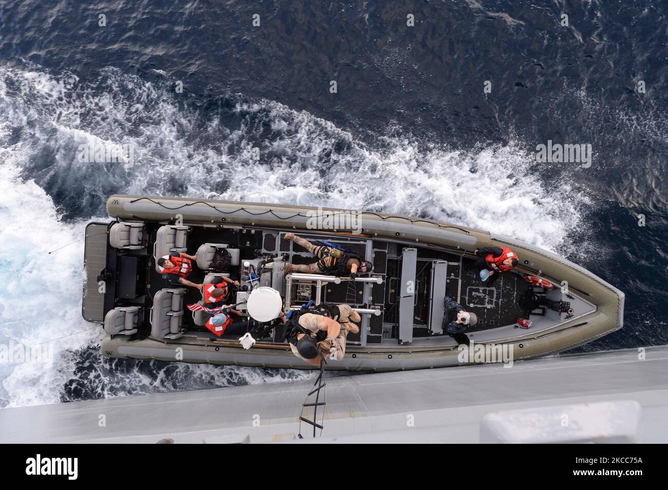 Une visite, un conseil, une fouille et une saisie grimpent une échelle Jacobs d'un bateau gonflable. Banque D'Images