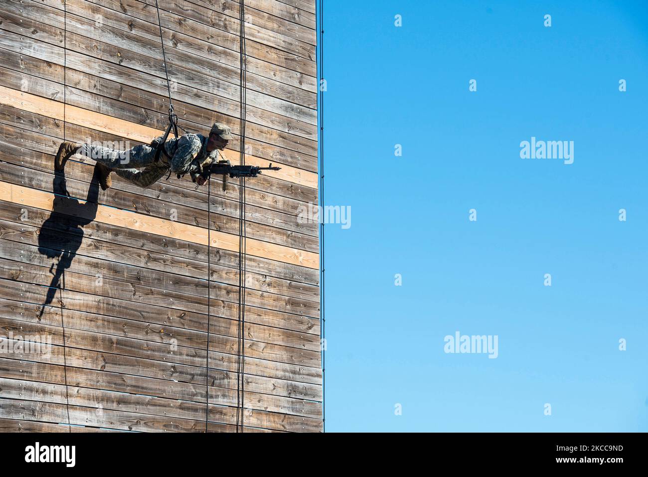 Un Ranger de l'armée américaine transportant une mitrailleuse légère de M249 s'enroule sur un mur. Banque D'Images