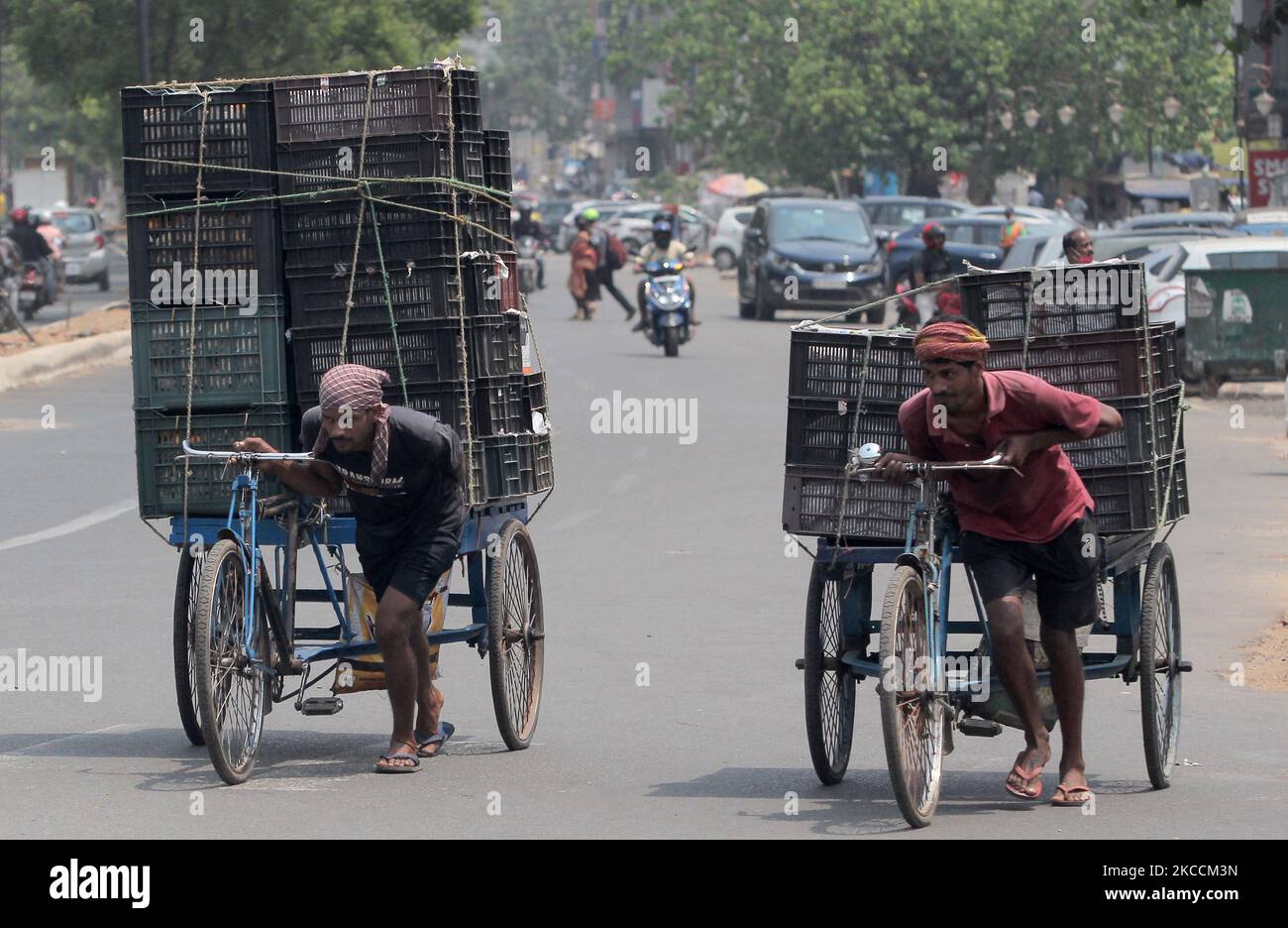 Trolley les tireurs de pousse-pousse tirent leurs marchandises chargées de chariot alors qu'ils sont en route vers la zone de marché quotidienne dans l'après-midi chaud dans l'est de l'état indien Odisha capitale, Bhubaneswar sur 12 avril 2021. (Photo par STR/NurPhoto) Banque D'Images