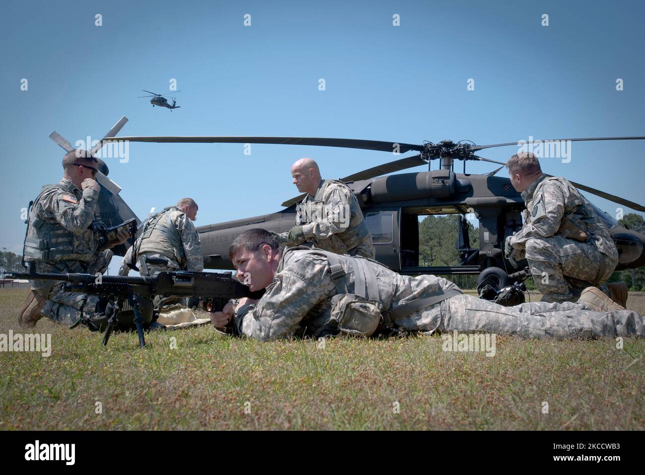 Les soldats établissent un périmètre de défense autour d'un hélicoptère UH-60 Black Hawk de l'armée américaine. Banque D'Images