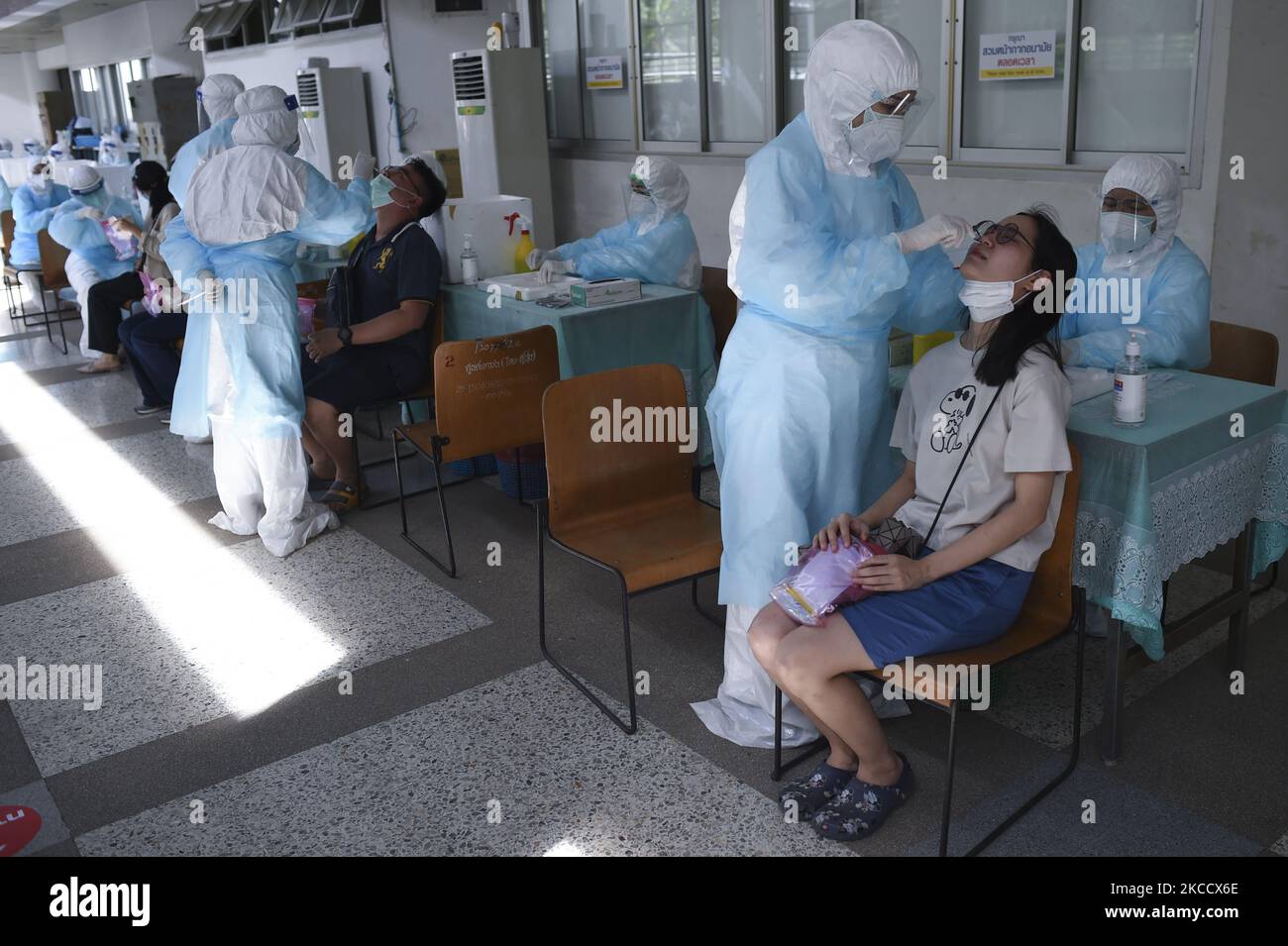 Un travailleur médical portant un EPI effectue un test par écouvillonnage pour le COVID-19 chez une femme lors d'un test par écouvillonnage nasal pour le COVID-19 dans le but d'arrêter la nouvelle vague de pandémie du coronavirus dans un complexe sportif de Bangkok, Thaïlande, 17 avril 2021. (Photo par Anusak Laowilas/NurPhoto) Banque D'Images