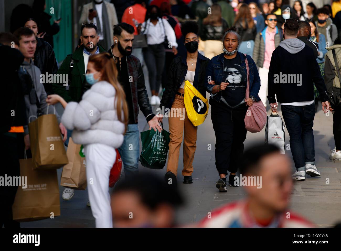 Les acheteurs portent des sacs le long d'une rue animée d'Oxford Street à Londres, en Angleterre, sur 17 avril 2021. En Angleterre, aujourd'hui a été le premier samedi des magasins de grande rue en plus de trois mois, avec des magasins de détail non essentiels rouvrant au début de cette semaine, alors que les mesures nationales de confinement du coronavirus ont été assouplies. (Photo de David Cliff/NurPhoto) Banque D'Images