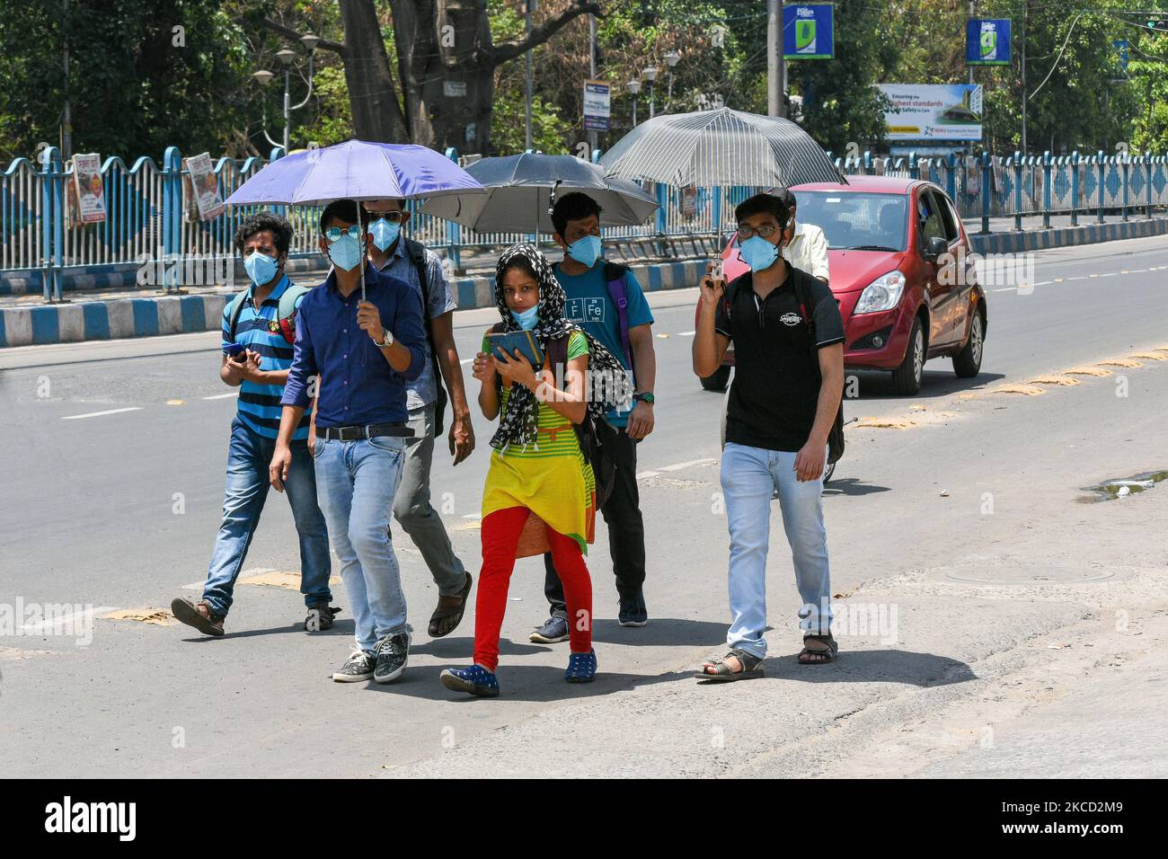 Les gens sont vus porter un masque et utiliser un parapluie pendant une chaude journée d'été , au milieu des cas croissants de COVID-19 à Kolkata, en Inde, le 19 avril 2021. L'Inde a enregistré plus de 2,6 cas de Lakh hier , selon un rapport des médias indiens. (Photo par Debarchan Chatterjee/NurPhoto) Banque D'Images