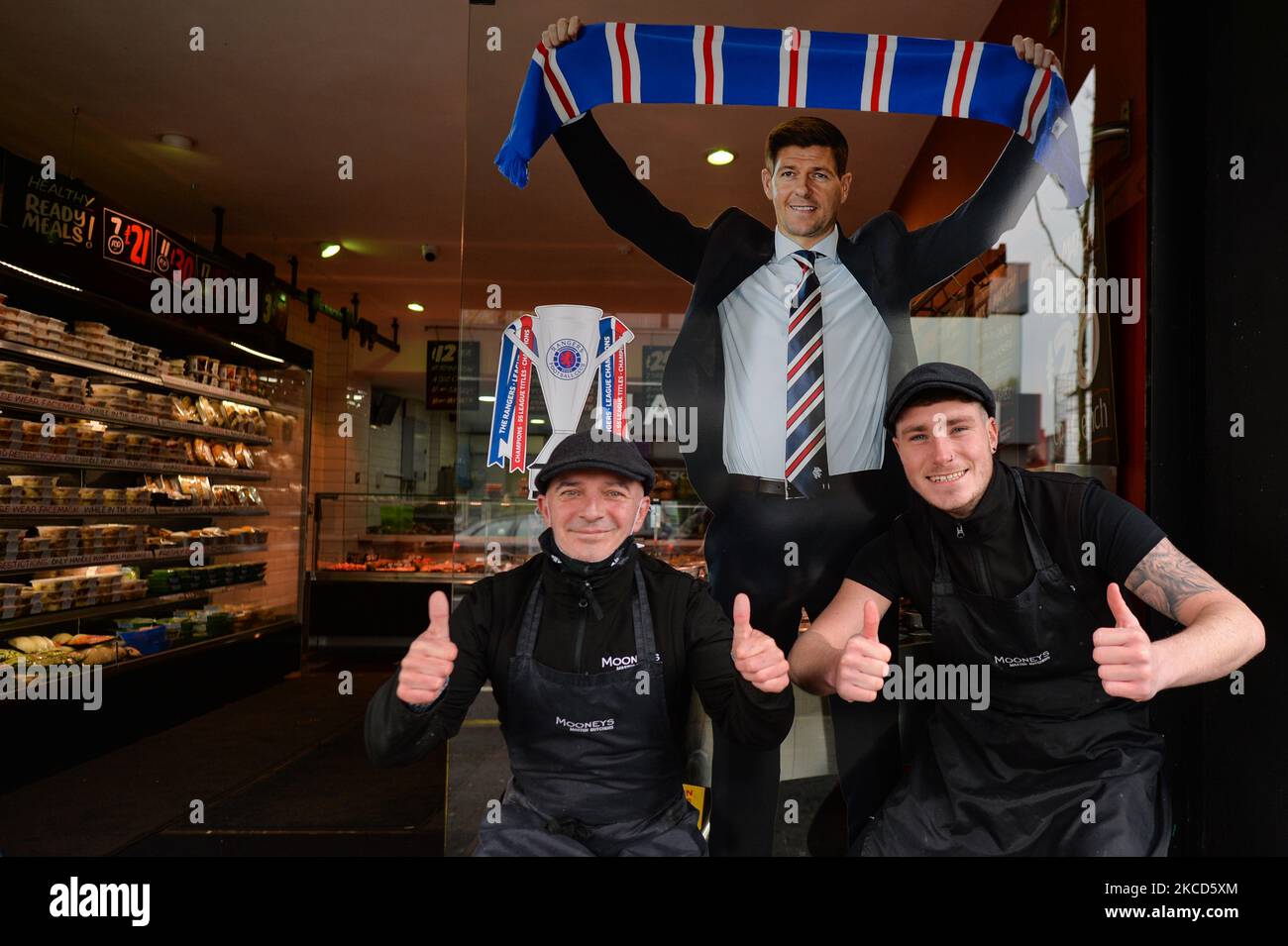 Deux membres du personnel de Mooneys Master Butchers posent pour une photo à l'extérieur de leur boutique avec une image de Steven Gerrard, un directeur de football anglais professionnel et ancien joueur qui gère actuellement les Scottish Premiership Club Rangers, vu sur Shankill Road, à Belfast. Mardi, 20 avril 2021, à Belfast, Irlande du Nord (photo d'Artur Widak/NurPhoto) Banque D'Images