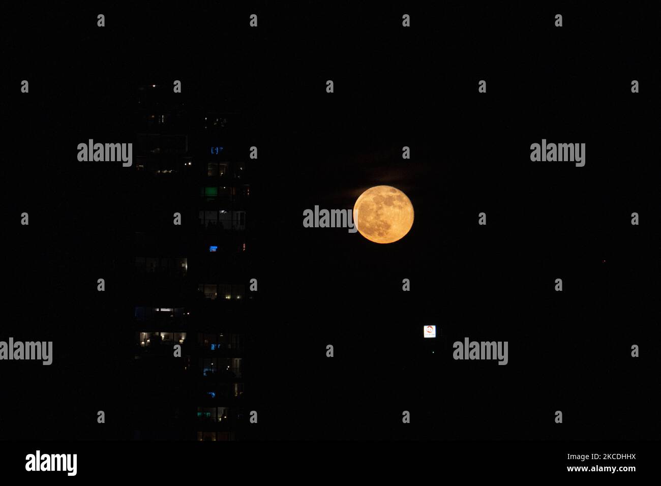 Photo Lune Pix Ville Pays La pleine lune ou la Superlune rose ou la Super Lune rose d'avril 2021, vue de la ville néerlandaise, Eindhoven, pays-Bas sur 27 avril 2021, s'élevant au-dessus de l'horizon derrière les bâtiments