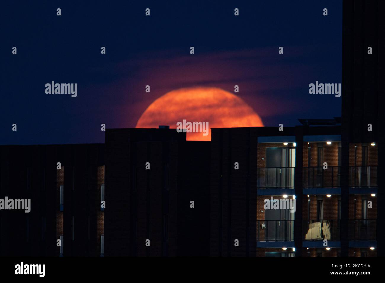 Photo Lune Pix Ville Pays La pleine lune ou la Superlune rose ou la Super Lune rose d'avril 2021, vue de la ville néerlandaise, Eindhoven, pays-Bas sur 27 avril 2021, s'élevant au-dessus de l'horizon derrière les bâtiments