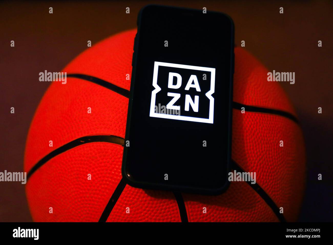 Le logo DAZN est affiché sur un écran de téléphone et un ballon de basket-ball. Cette photo d'illustration a été prise à Cracovie, en Pologne, sur 30 avril 2021. (Photo de Jakub Porzycki/NurPhoto) Banque D'Images