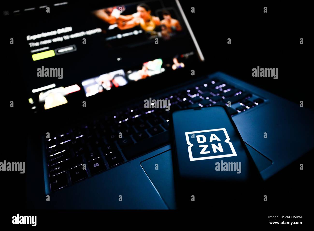 Le logo DAZN affiché sur l'écran d'un téléphone et un site Web affiché sur l'écran d'un ordinateur portable sont illustrés sur cette photo prise à Cracovie, en Pologne, sur 30 avril 2021. (Photo de Jakub Porzycki/NurPhoto) Banque D'Images