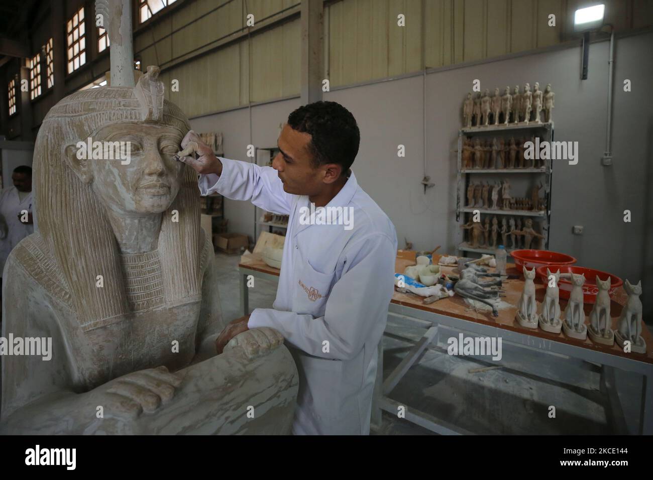 Ouvrier a l'usine de Kunooz, le Caire, Egypte, on 4 mai 2021, la première usine de répliques antiques de la région. Les produits seront exportés en dehors de l'Egypte en plus de leur participation à des foires touristiques étrangères.cette usine a été achevée à la fin de 2020, puis a commencé son exploitation d'essai, au cours de laquelle elle a produit 6 400 pièces de bois, céramique, pierre, métal, Et une collection de trésors du roi Toutankhamon.chaque clone antique produit à l'usine porte un timbre spécial du Conseil suprême des antiquités, et un certificat approuvé indiquant qu'il s'agit d'une fausse pièce et d'une copie véritable et Th Banque D'Images