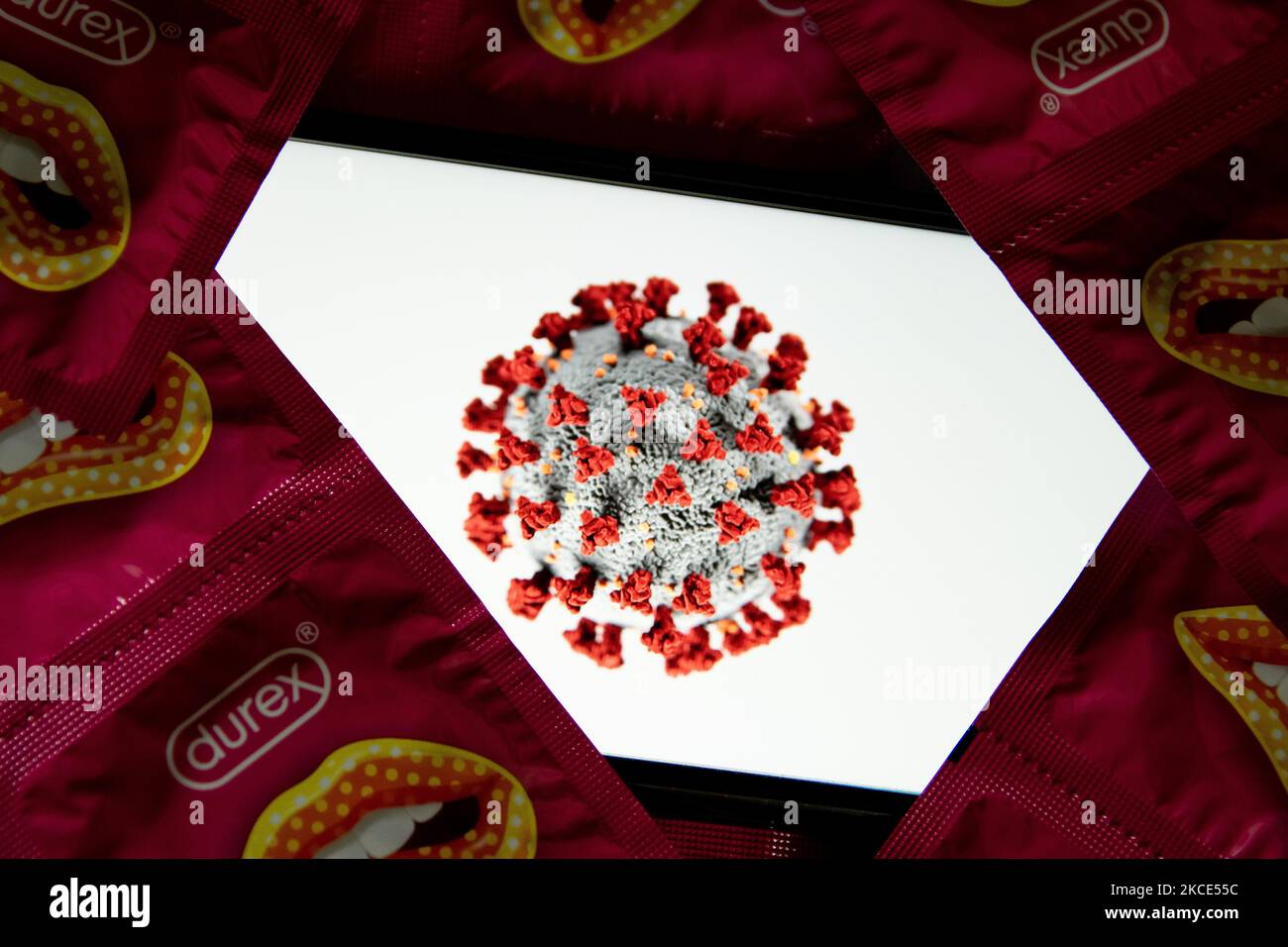 Dans cette illustration, un logo du coronavirus (Covid-19) sur un écran de smartphone, avec des condoms Durex sont exposés à Athènes, Grèce sur 8 mai 2021. (Photo Illustration par Nikolas Kokovlis/NurPhoto) Banque D'Images