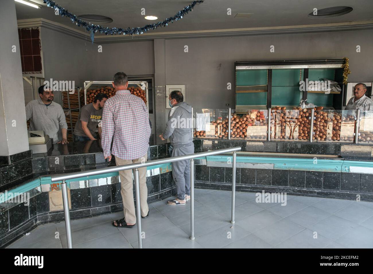 Les gens achètent du pain dans une boulangerie de la ville d'Ariana, région du Grand Tunis, Tunisie sur 13 mai 2021. Alors que les musulmans du monde entier célèbrent Eid ul-Fitr, et en raison du verrouillage partiel imposé par les autorités tunisiennes pour ralentir la propagation de la pandémie COVID-19, les fidèles n’ont pas exécuté la prière Eid ul-Fitr dans les mosquées fermées. Même les cafés étaient fermés, et il n'y avait aucune manifestation de festivités dans les rues. Les Tunisiens achètent simplement du pain, puis du Rentre à la maison. EID ul-Fitr également appelé le 'Festival of Breaking the Fast' ou Lesser Eid, est une fête religieuse Banque D'Images