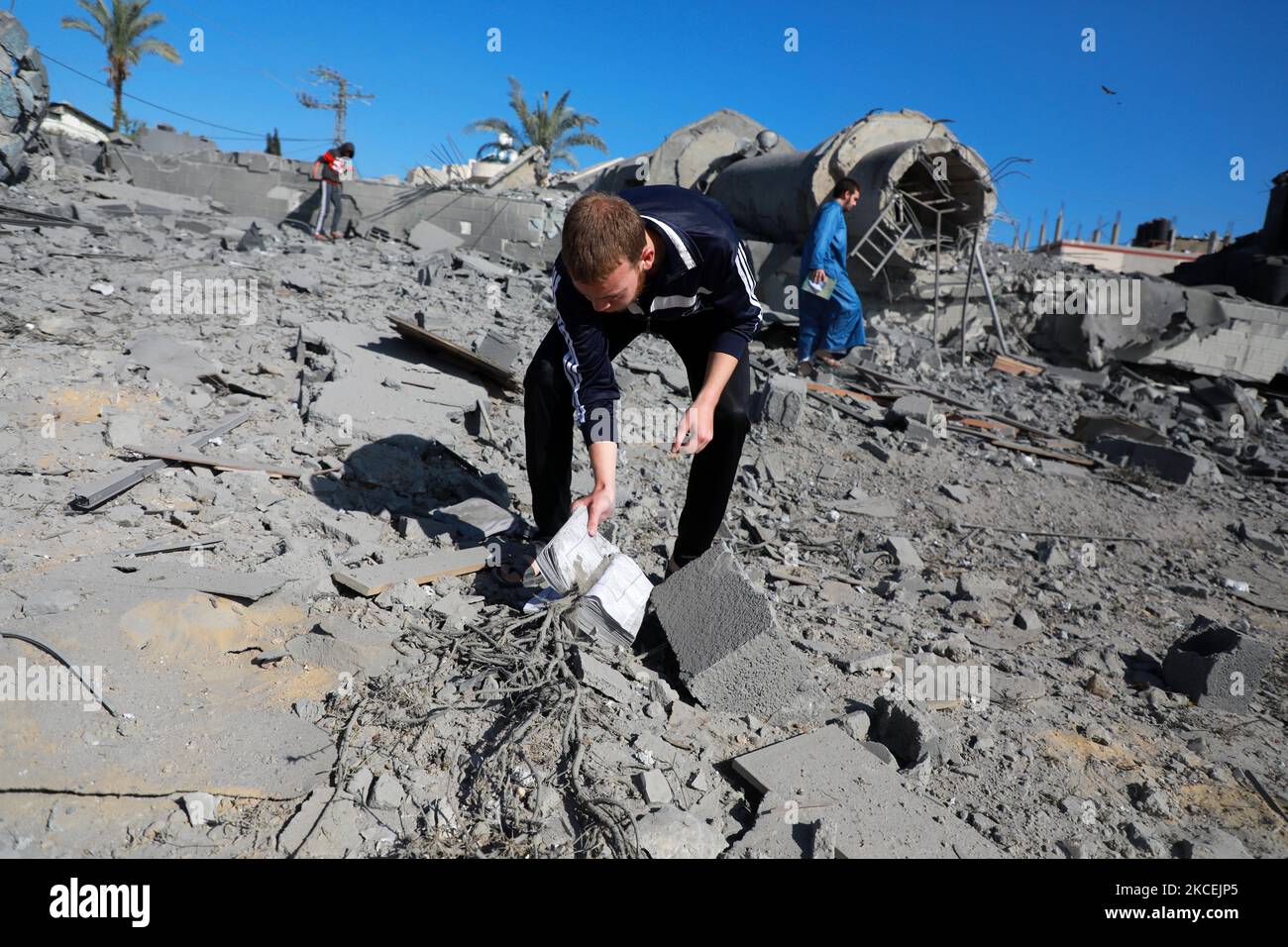 Un palestinien recueille des pages du Coran sur les ruines de la mosquée Abdul Razzaq Qlebo détruite après une attaque aérienne israélienne au camp de réfugiés de Jabalia, dans le nord de la bande de Gaza, au 15 mai 2021. - Des avions de chasse israéliens ont traqué la bande de Gaza pendant la nuit, tuant 10 membres d'une seule famille, a déclaré M. Medics, après une journée de violence meurtrière qui a secoué la Cisjordanie et un envoyé américain est arrivé pour des pourparlers. (Photo de Majdi Fathi/NurPhoto) Banque D'Images