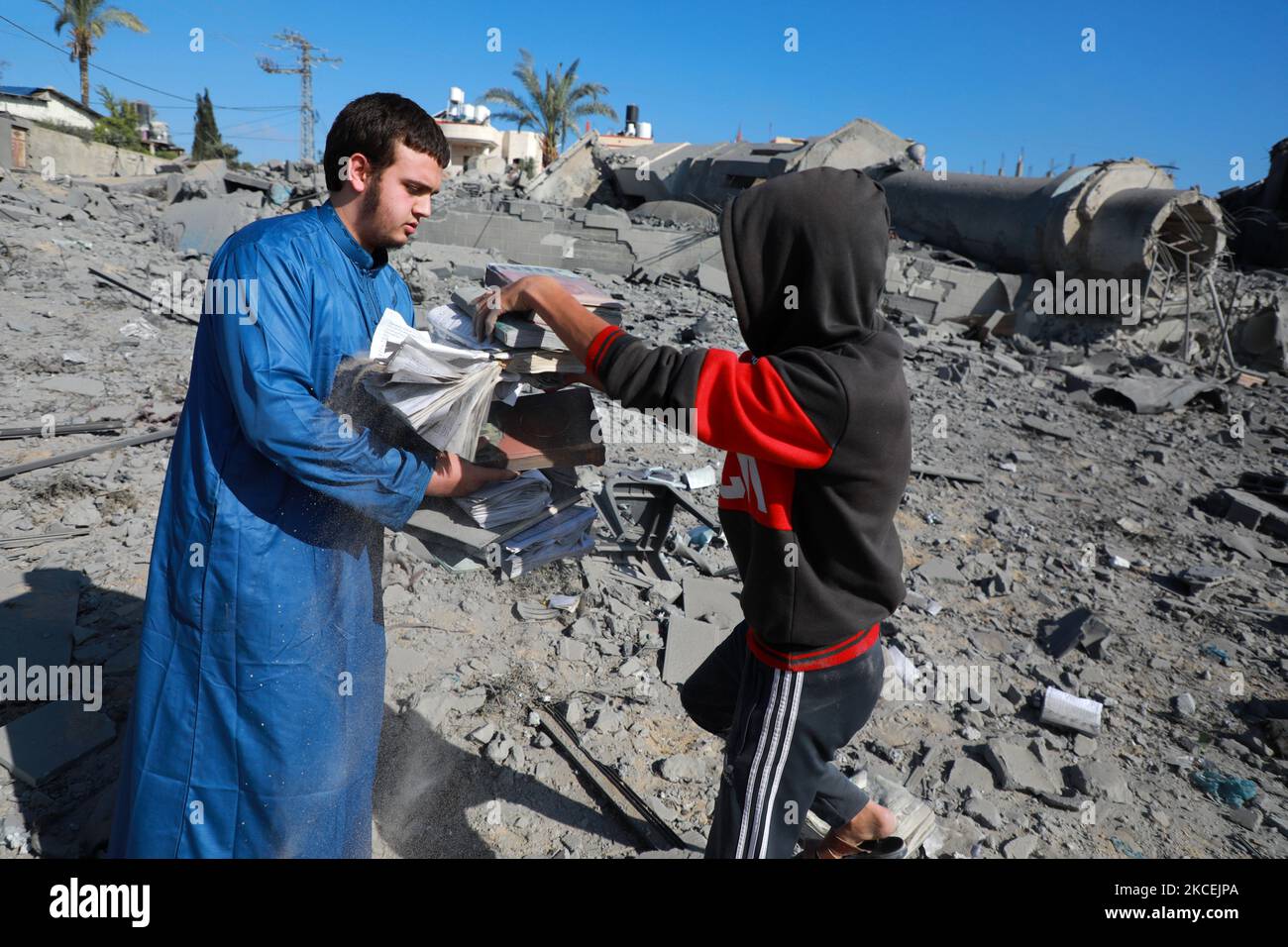 Un palestinien recueille des pages du Coran sur les ruines de la mosquée Abdul Razzaq Qlebo détruite après une attaque aérienne israélienne au camp de réfugiés de Jabalia, dans le nord de la bande de Gaza, au 15 mai 2021. - Des avions de chasse israéliens ont traqué la bande de Gaza pendant la nuit, tuant 10 membres d'une seule famille, a déclaré M. Medics, après une journée de violence meurtrière qui a secoué la Cisjordanie et un envoyé américain est arrivé pour des pourparlers. (Photo de Majdi Fathi/NurPhoto) Banque D'Images