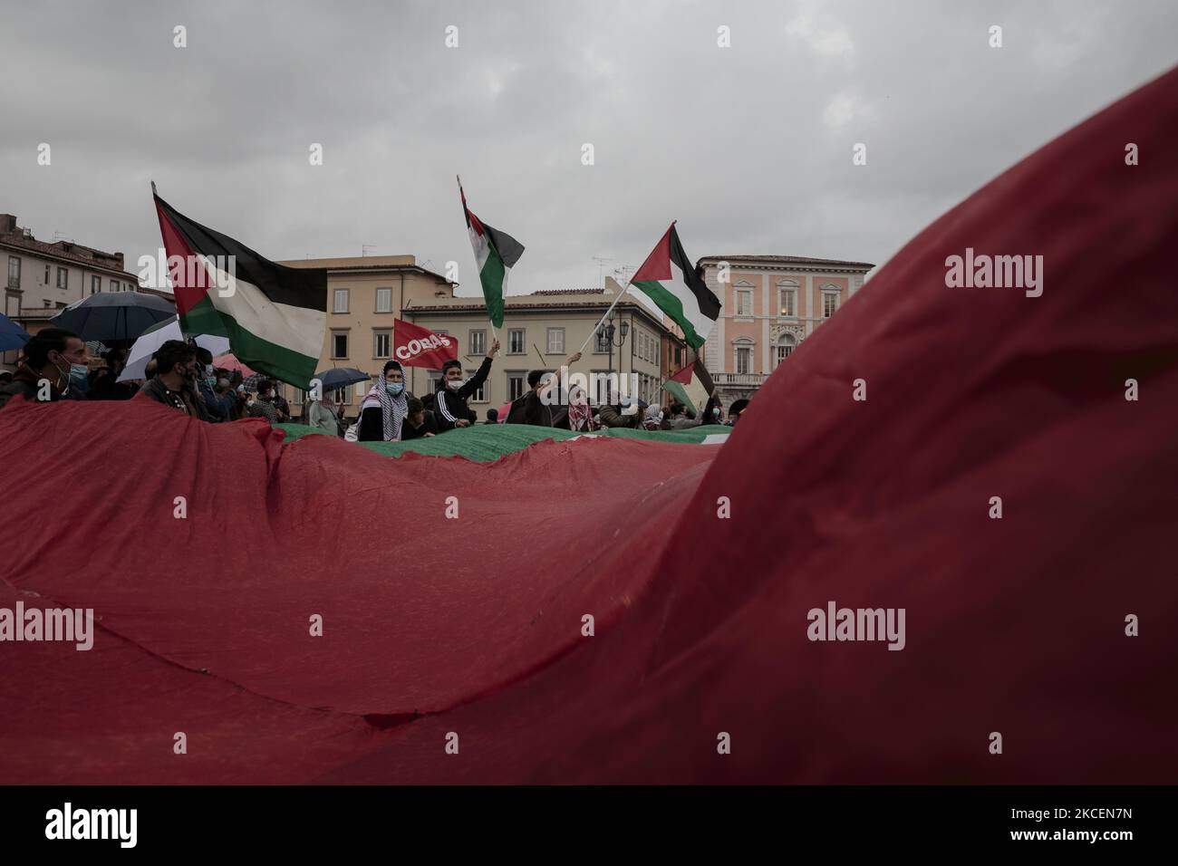 Des manifestants branding et agitant un immense drapeau palestinien à Pise, en Italie, sur 15 mai 2021. L'escalade entre Israël et la Palestine a conduit à une frappe aérienne transfrontalière au cours des derniers jours. Les membres de la communauté palestinienne et leurs partisans manifestent contre les actions d'Israël envers les Palestiniens à Gaza. 15 mai est également le jour où les Palestiniens commémorent Nakba pour se souvenir des quelque 700 000 000 Palestiniens qui ont été déplacés de leurs foyers après la formation d'Israël en 1948. (Photo par Enrico Mattia Del Punta/NurPhoto) Banque D'Images