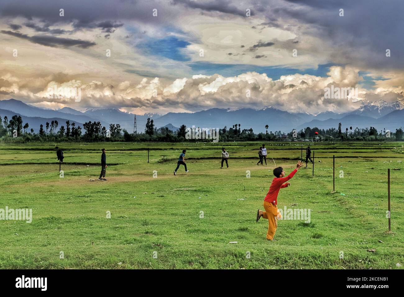 Un garçon tente de prendre une balle alors qu'il joue au cricket au milieu du coronavirus COVID-19 à Sopore, district de Baramulla, Jammu-et-Cachemire, Inde, le 16 mai 2021. (Photo de Nasir Kachroo/NurPhoto) Banque D'Images
