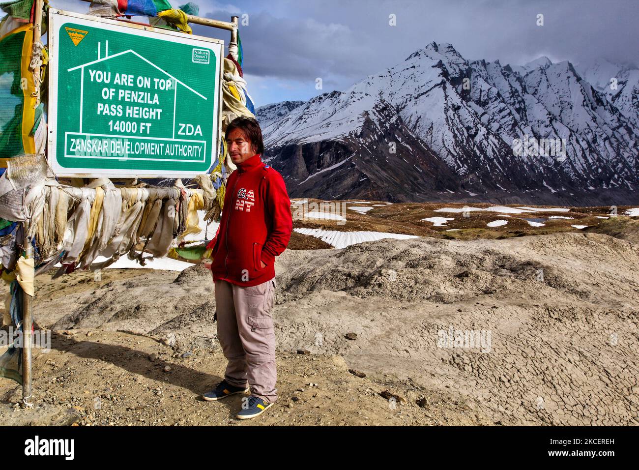 Homme debout par un panneau au sommet du col de Panzila (col de Panjila) dans la vallée de Suru à Zanskar, Ladakh, Jammu et Cachemire, Inde. Le col de Panzilla est le point le plus élevé entre Kargil et Padam. Le col de Panzilla sépare la vallée de Suru de la vallée de Zanskar et est connu comme la porte d'entrée de Zanskar. Le col de Panzila est situé à une altitude de 4 400 m (14 436 pi) au-dessus du niveau de la mer et relie la région de la vallée de Suru à la région de la vallée de Zanskar. (Photo de Creative Touch Imaging Ltd./NurPhoto) Banque D'Images