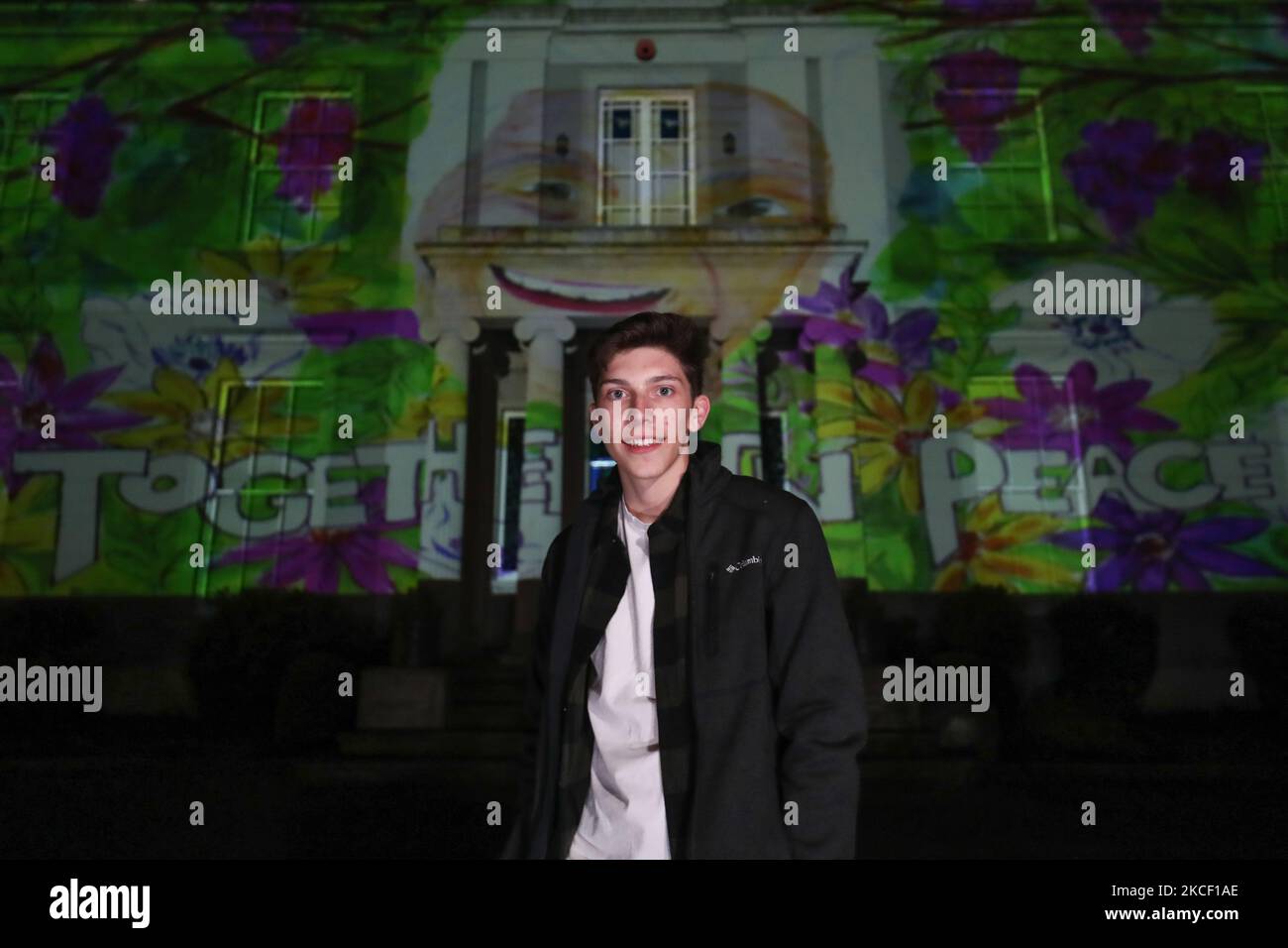 Ben Cole avec son œuvre projetée sur Hazelwood Integrated College à Belfast, dans le cadre du nouveau projet parallèle de paix de Herstory à Belfast lancé à l'occasion de la Journée mondiale de la diversité culturelle pour le dialogue et le développement. Des militants israéliens, palestiniens et irlandais de la paix ont participé au projet qui raconte l'histoire des femmes et des filles de l'île d'Irlande dont la vie a été affectée par le conflit en Irlande du Nord. Le jeudi 20 mai 2021, à Belfast, Irlande du Nord. (Photo par Artur Widak/NurPhoto) Banque D'Images