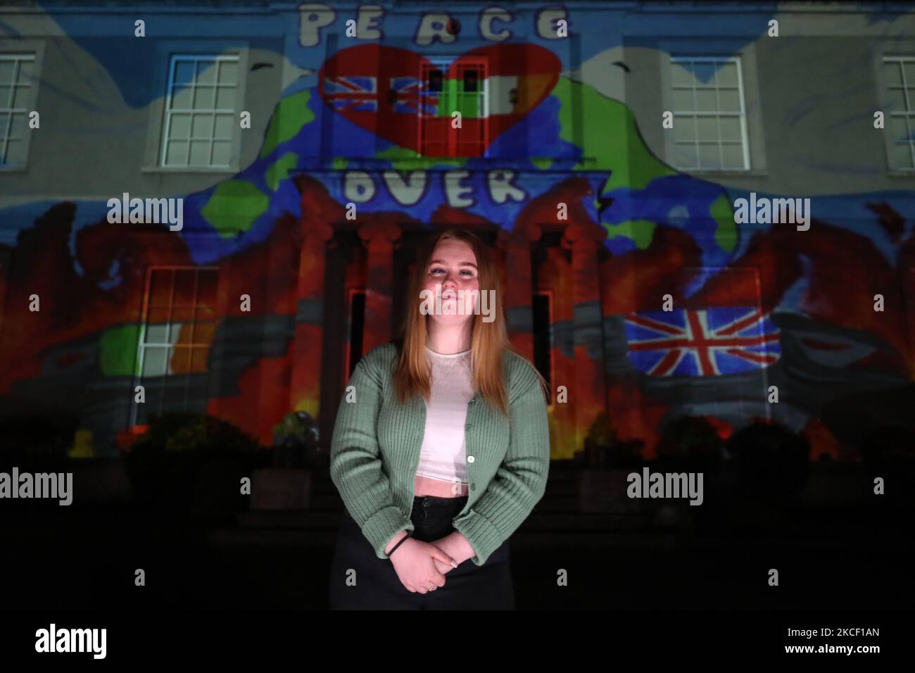 Faith Lyttle avec son œuvre projetée sur Hazelwood Integrated College à Belfast, dans le cadre du nouveau projet parallèle de paix de Herstory à Belfast lancé à l'occasion de la Journée mondiale de la diversité culturelle pour le dialogue et le développement. Des militants israéliens, palestiniens et irlandais de la paix ont participé au projet qui raconte l'histoire des femmes et des filles de l'île d'Irlande dont la vie a été affectée par le conflit en Irlande du Nord. Le jeudi 20 mai 2021, à Belfast, Irlande du Nord. (Photo par Artur Widak/NurPhoto) Banque D'Images