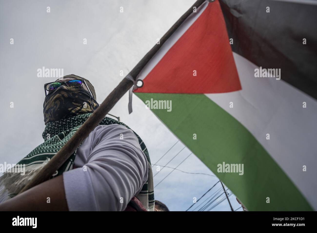 Un manifestant porte un drapeau palestinien tout en participant à une manifestation de solidarité à Palu, dans la province centrale de Sulawesi, en Indonésie, sur 21 mai 2021. L'action de solidarité qui a été suivie par les membres de l'organisation musulmane est une forme de soutien et de défense des Palestiniens pour les attaques sionistes et les atrocités israéliennes. Gaza est à l'origine de la crise humanitaire dans la région. (Photo de Basri Marzuki/NurPhoto) Banque D'Images