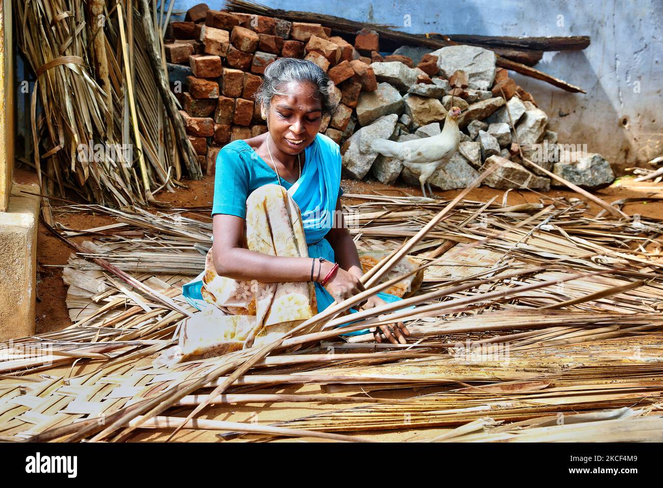 Femme du village en tissage de murs pour sa maison rurale à partir de feuilles de palmier dans le village de Sokkankudiaruppu à Tamil Nadu, Inde. La plupart des maisons sont construites de boue et de feuilles de palmier avec des poutres en bois pour le soutien. (Photo de Creative Touch Imaging Ltd./NurPhoto) Banque D'Images