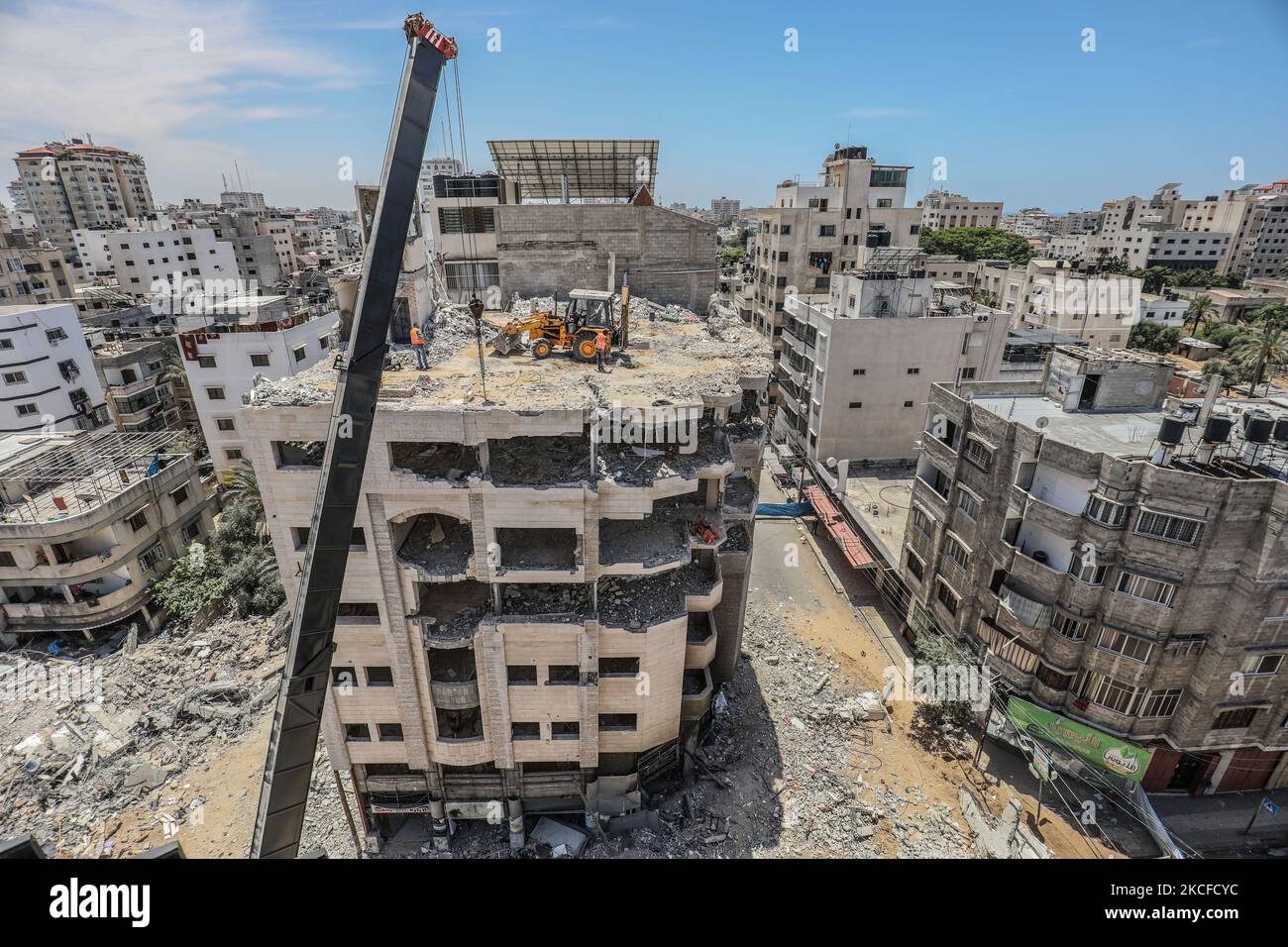 Du matériel de construction lourd est utilisé pour démolir un bâtiment détruit lors des frappes aériennes israéliennes de la semaine dernière sur la ville de Gaza. Israël et le mouvement islamiste palestinien Hamas ont jusqu'à présent respecté un cessez-le-feu convenu qui a eu lieu vendredi 21 mai après 11 jours de confrontations mortelles. (Photo de Mamen Faiz/NurPhoto) Banque D'Images