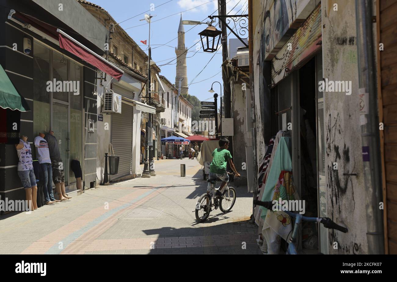 Un garçon chypriote turc passe à vélo le long d'une rue commerçante dans un territoire occupé par la Turquie, dans la partie nord de la capitale divisée Nicosie. Chypre, vendredi, 4 juin 2021. Chypre divisée sur le plan ethnique a franchi une étape clé vers un retour à son rythme de vie normal au milieu de la pandémie vendredi, lorsque neuf points de passage le long d'une zone tampon contrôlée par les Nations Unies ont été rouverts, permettant ainsi aux Chypriotes ordinaires de franchir la ligne de partage. (Photo de Danil Shamkin/NurPhoto) Banque D'Images