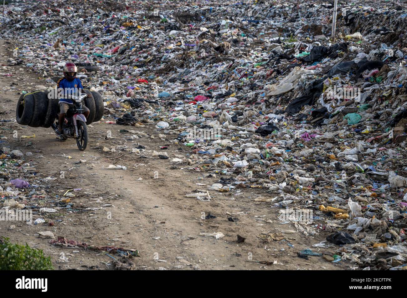 Un éliminateur transporte ses pneus décharmés à la décharge de POI Panda, Kawatuna, ville de Palu, province centrale de Sulawesi, en Indonésie, sur 8 juin 2021. Le Ministère indonésien de l'environnement a déclaré qu'il y avait environ 36,94 millions de tonnes de décharges en 2020 et 52, 95 pour cent ou 19,56 millions de tonnes ont été traitées selon le concept de 3R (réduire, réutiliser et recycler), alors que le reste n'était pas géré. Dans le même temps, le National Plastic action Partnership (NPAP) Indonesia a déclaré que l'Indonésie produit environ 6,8 millions de tonnes de déchets plastiques par an, et que 61 pour cent de ces déchets ne sont pas gérés. Le NPAP Indonésie l'estime Banque D'Images