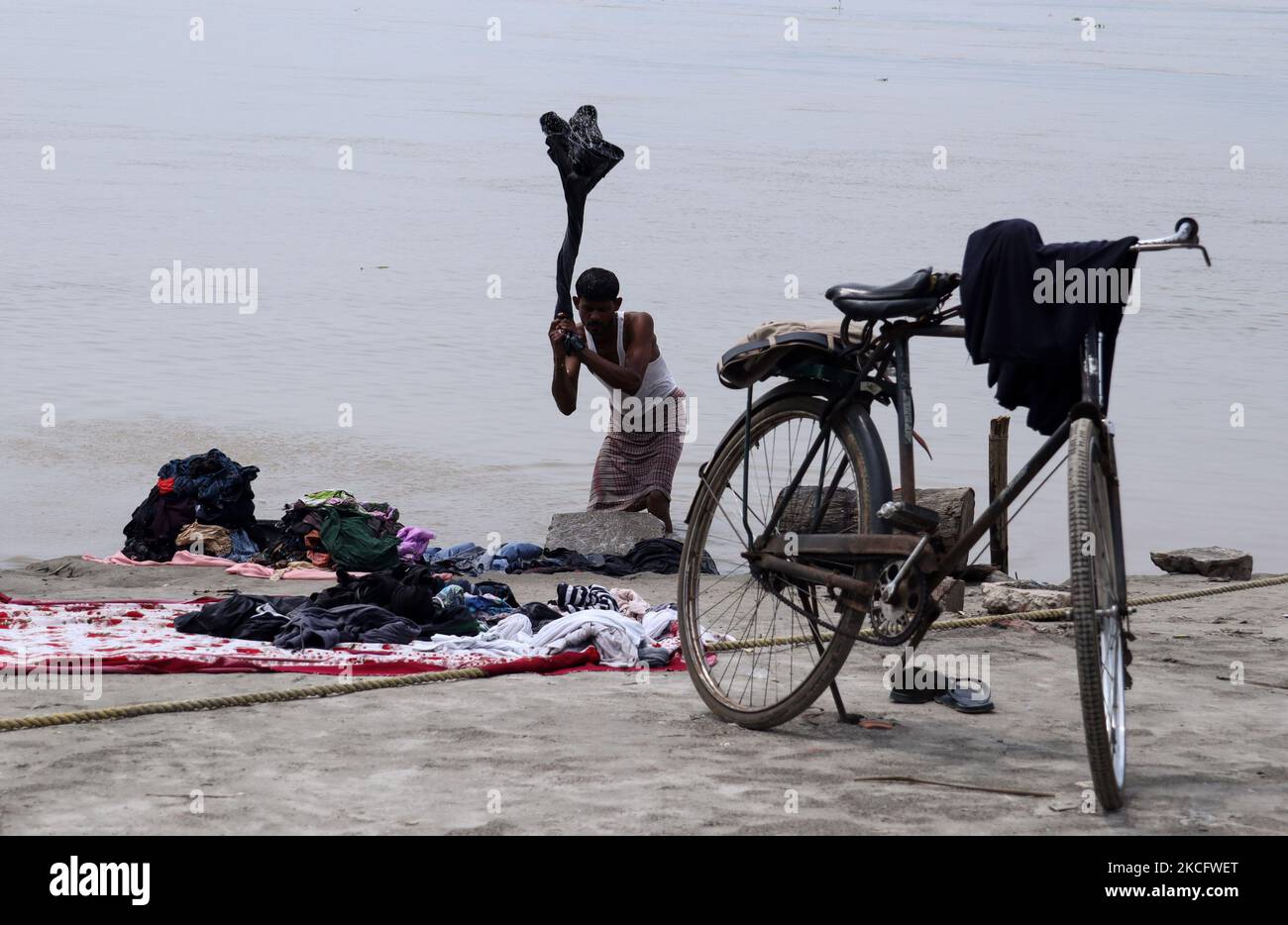 Un homme lavant des vêtements sur les rives du fleuve Brahmaputra à Guwahati, en Inde, le 09 juin 2021. (Photo de David Talukdar/NurPhoto) Banque D'Images