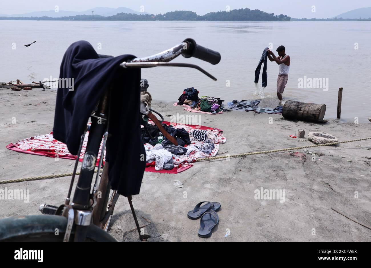 Un homme lavant des vêtements sur les rives du fleuve Brahmaputra à Guwahati, en Inde, le 09 juin 2021. (Photo de David Talukdar/NurPhoto) Banque D'Images